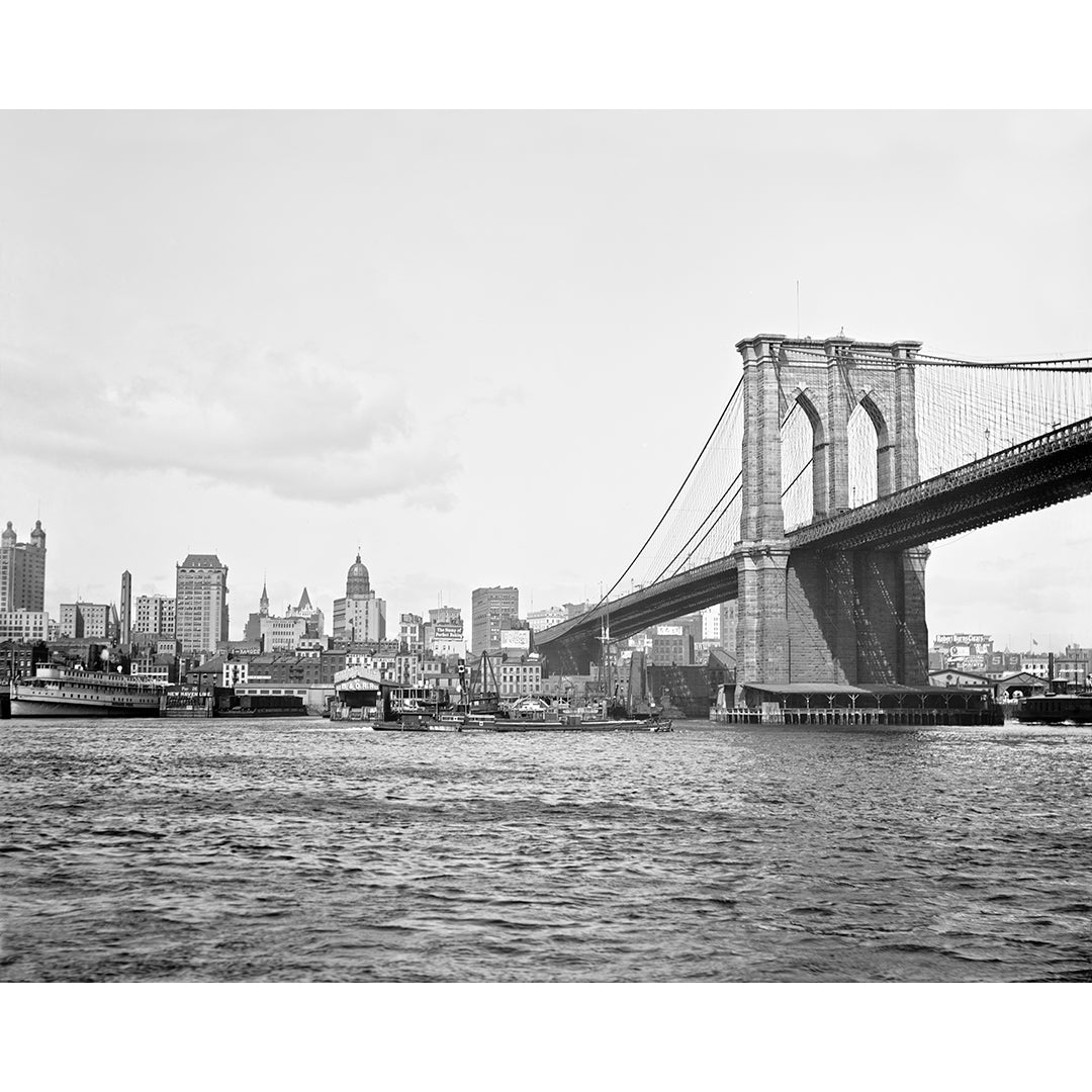 A vintage, black and white photograph of a portion of the Brooklyn Bridge and New York City skyline