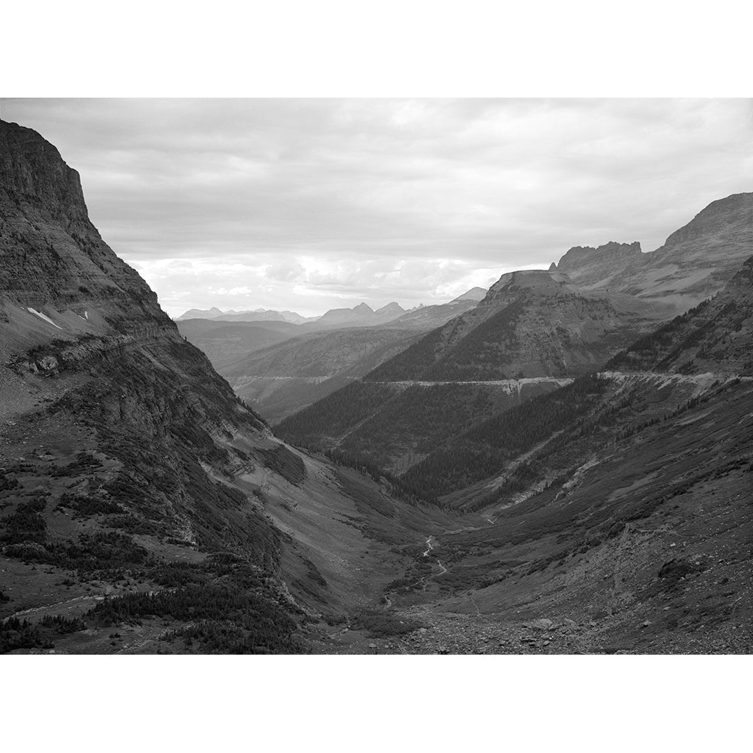 A black and white vintage landscape photograph of the Rockies in Glacier National Park