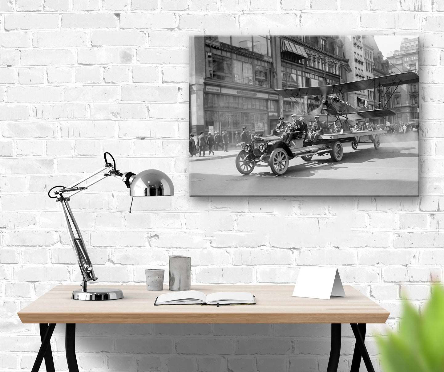 A canvas print hanging on a brick wall, featuring a vintage photograph of a parade in NYC