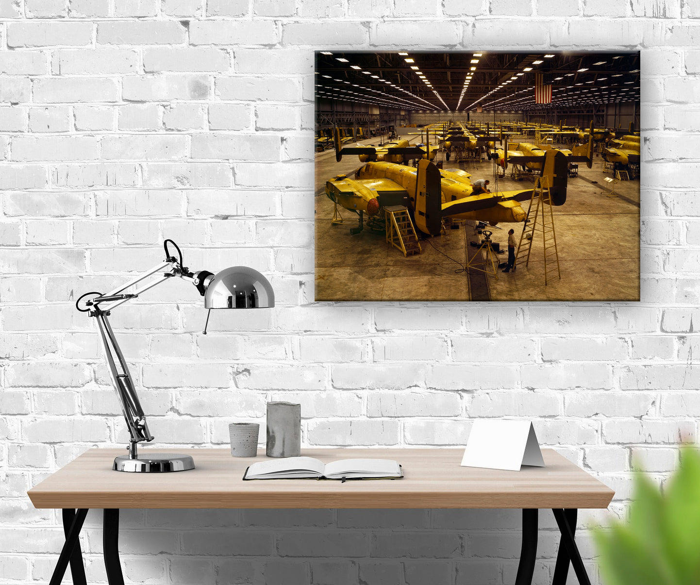 A digital mockup feauring a canvas print on a white brick wall above a desk