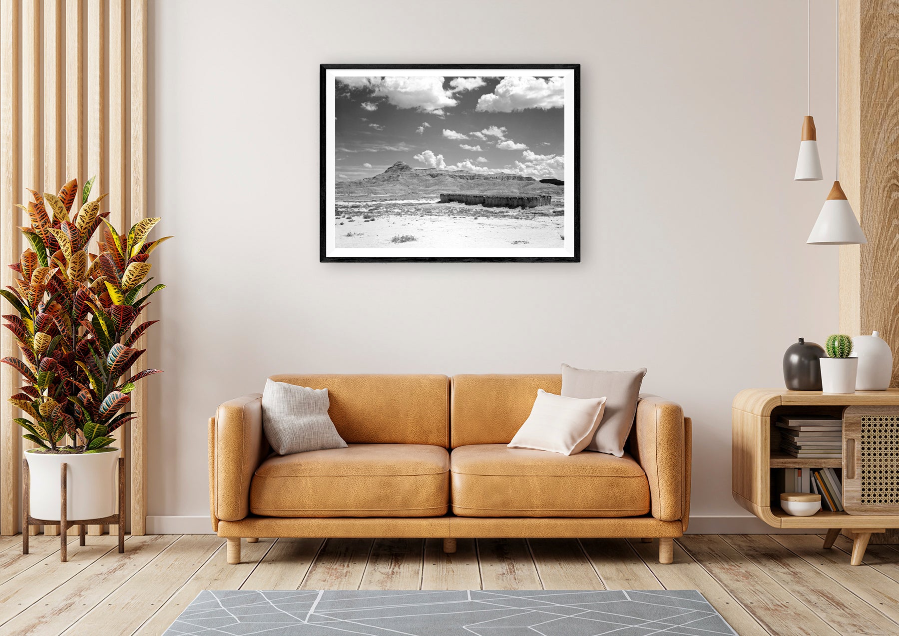 A framed print on paper of a vintage landscape photograph hanging in a living room