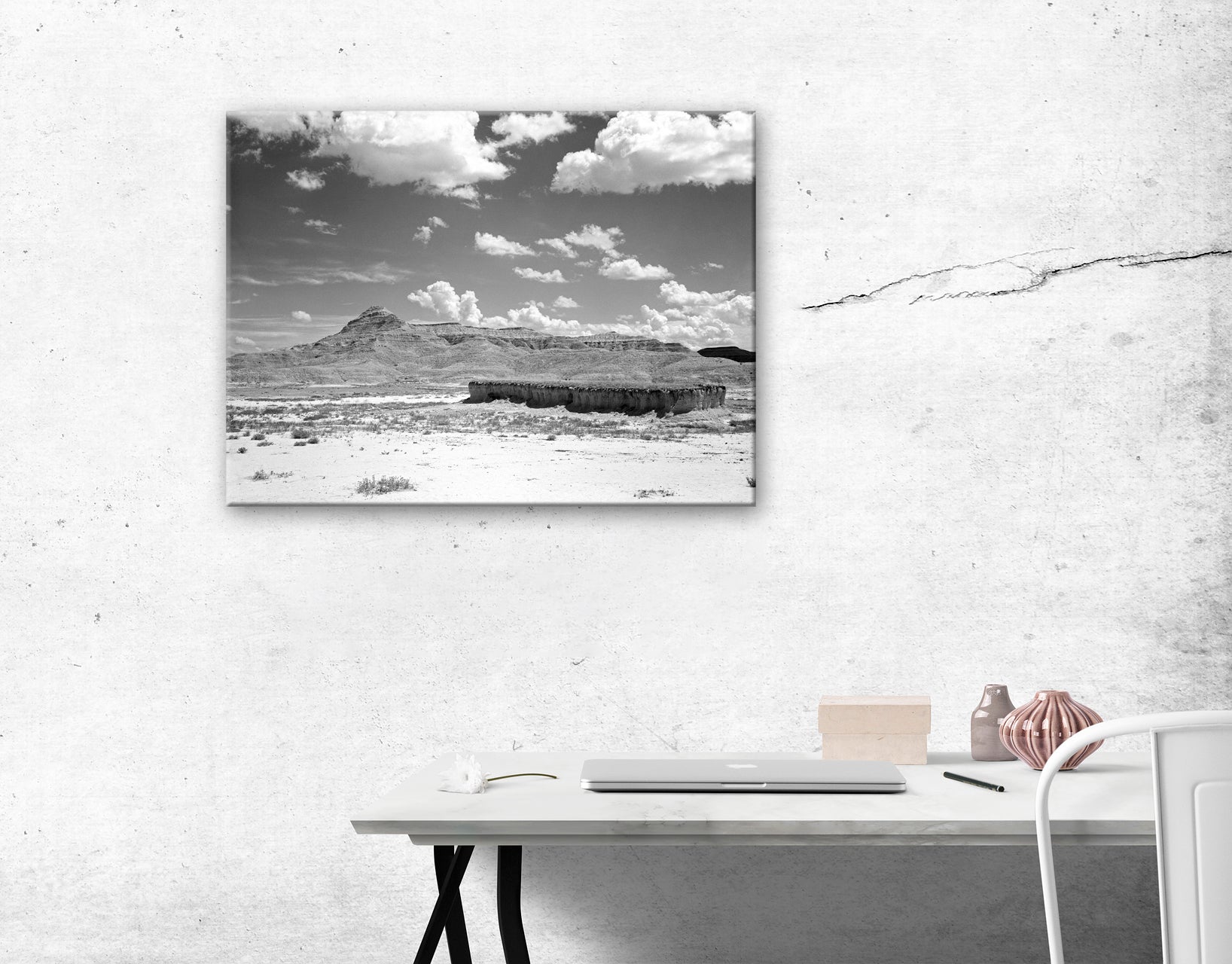 A canvas reproduction print of a vintage landscape photograph hanging on a wall above a desk