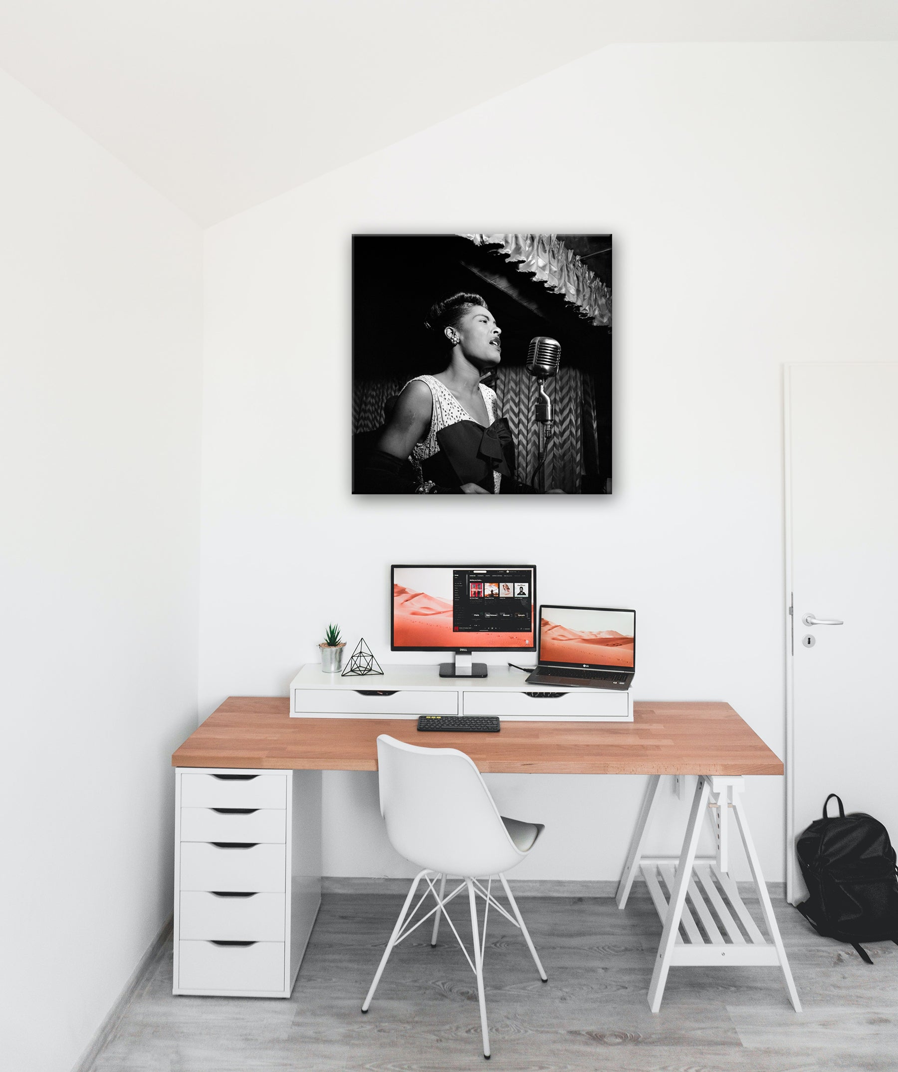 A white monochrome office with a canvas print of Billie Holiday hanging above the desk