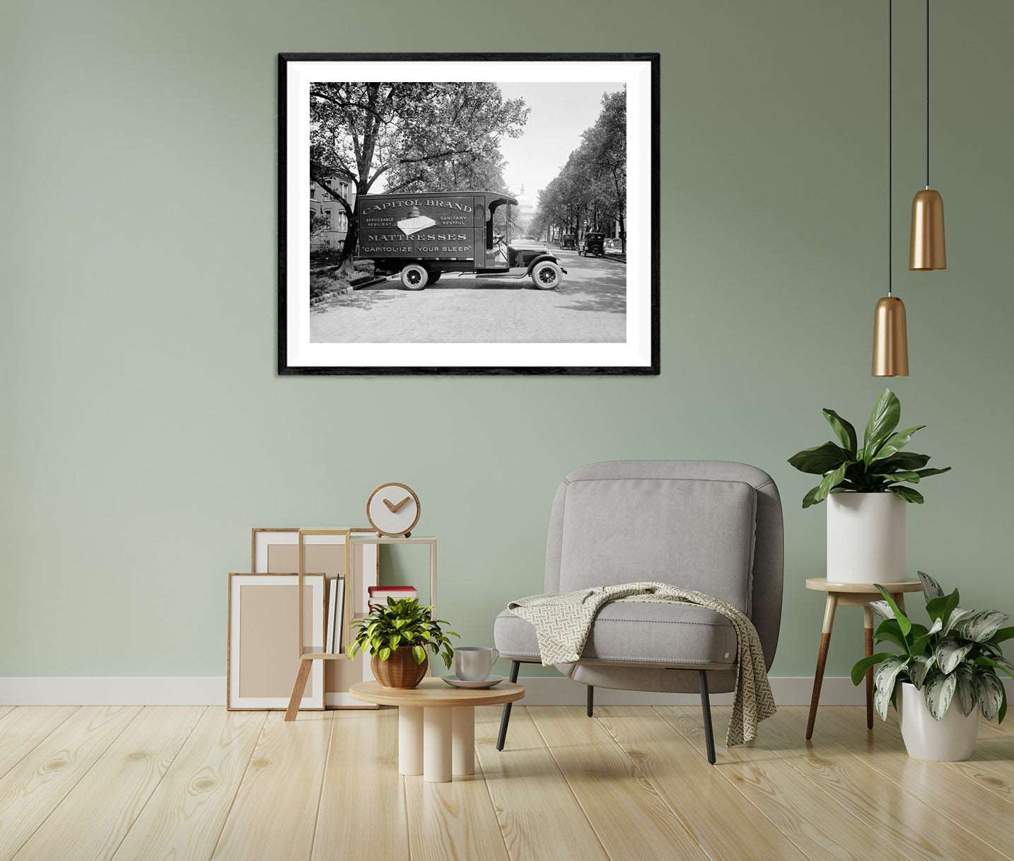 A framed paper print of a black and white photograph of a Ford vehicle hanging on a green wall