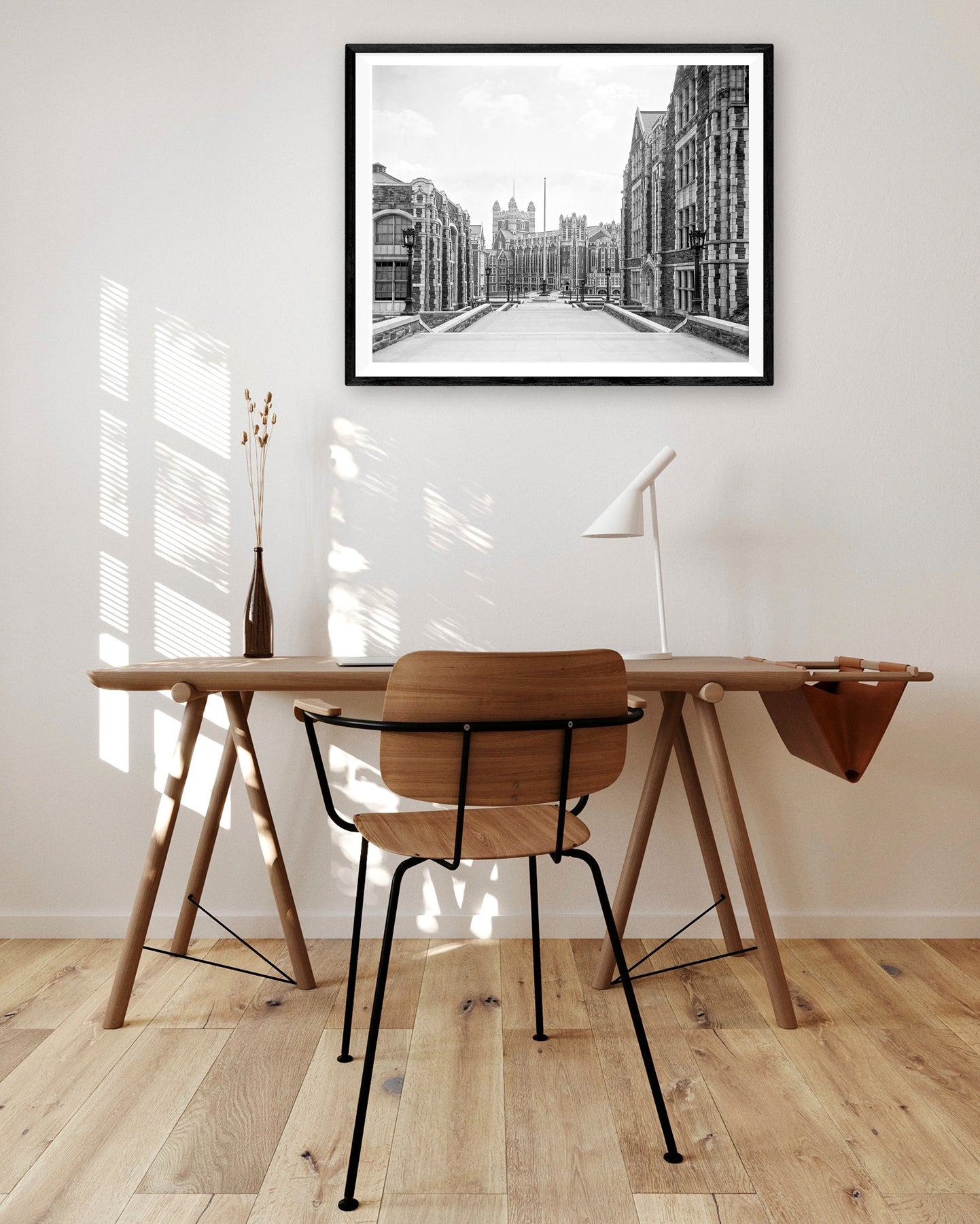 A vintage photo of New York City's City College printed on paper and framed, hanging above a desk