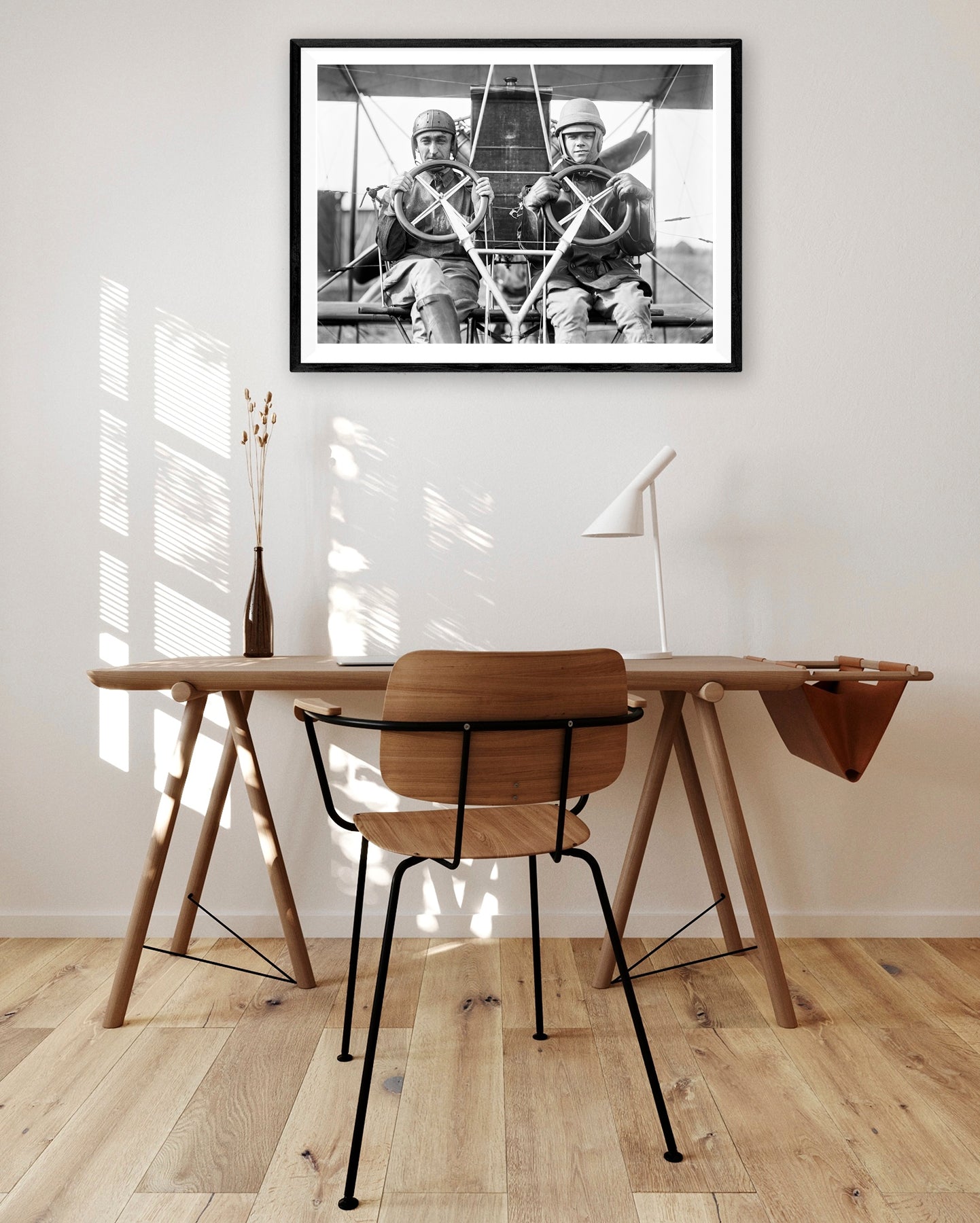 A brown desk with a framed paper print hanging above