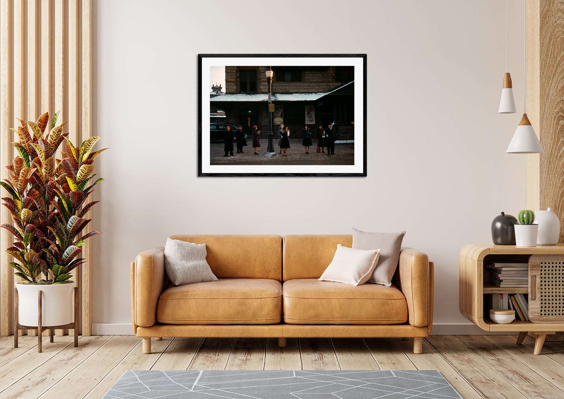 A photo of a living room with a framed paper print above the couch featuring a vintage color photograph