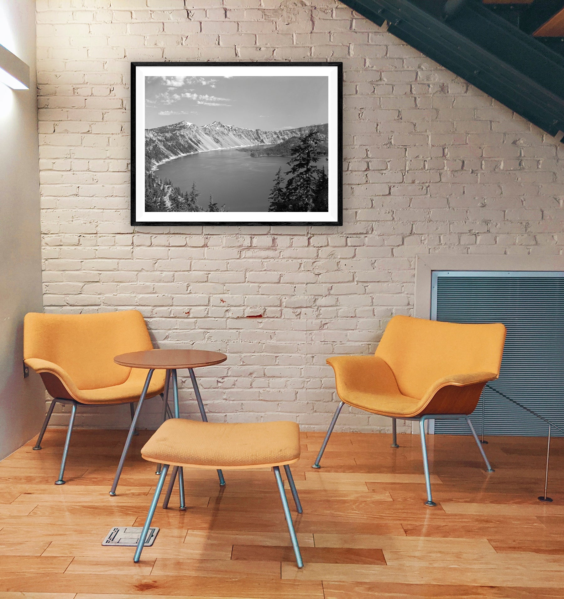An office space with a brick wall and a framed paper print of a vintage photograph