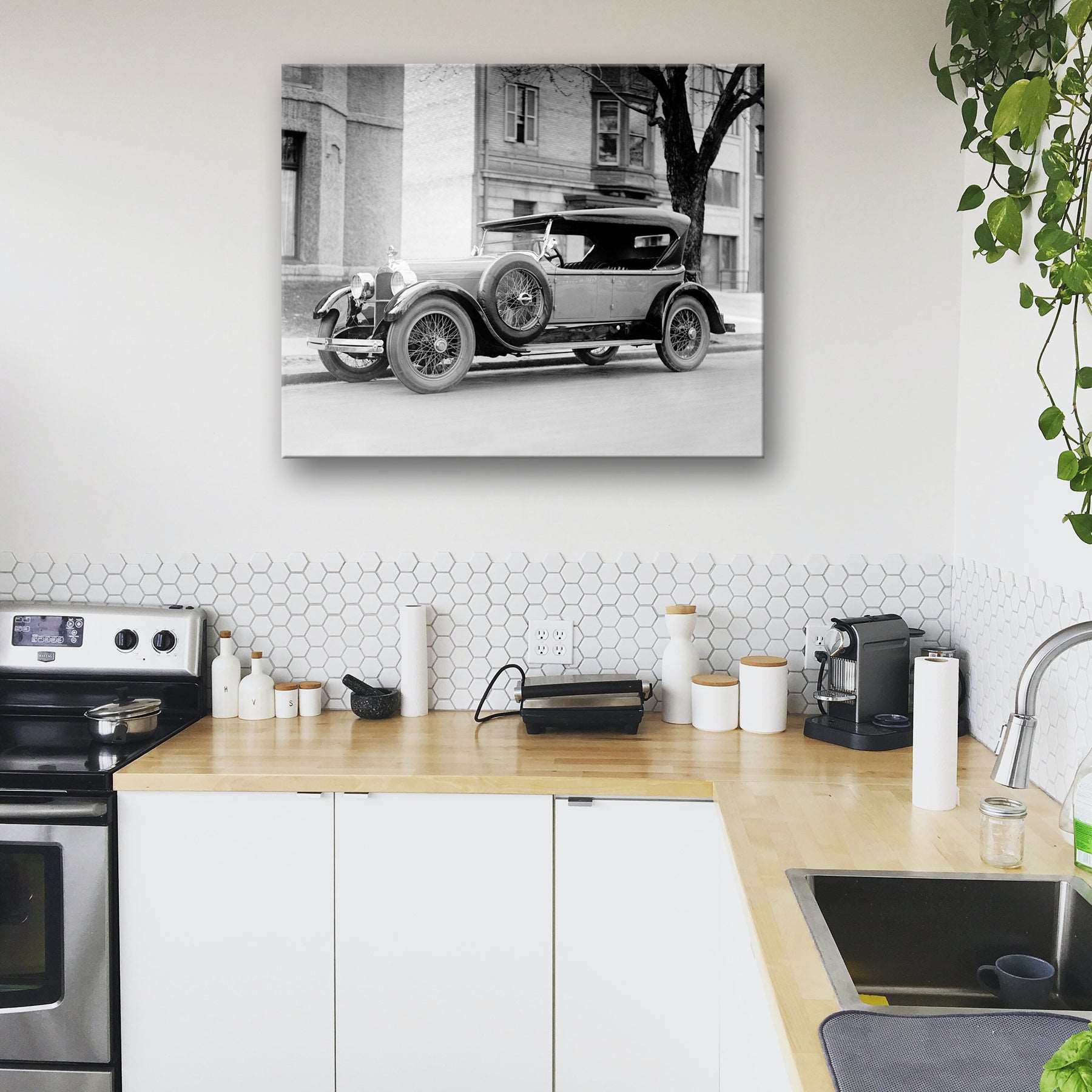 A modern kitchen with a canvas print of a vintage photograph of a Dusenberg Car on the wall