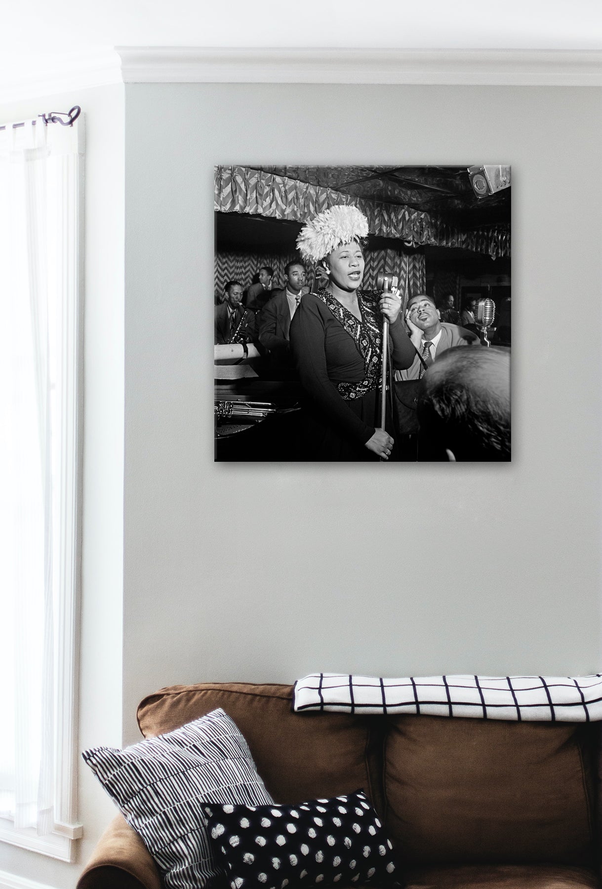 A canvas print of a photograph of Ella Fitzgerald hanging in a living room with a brown couch