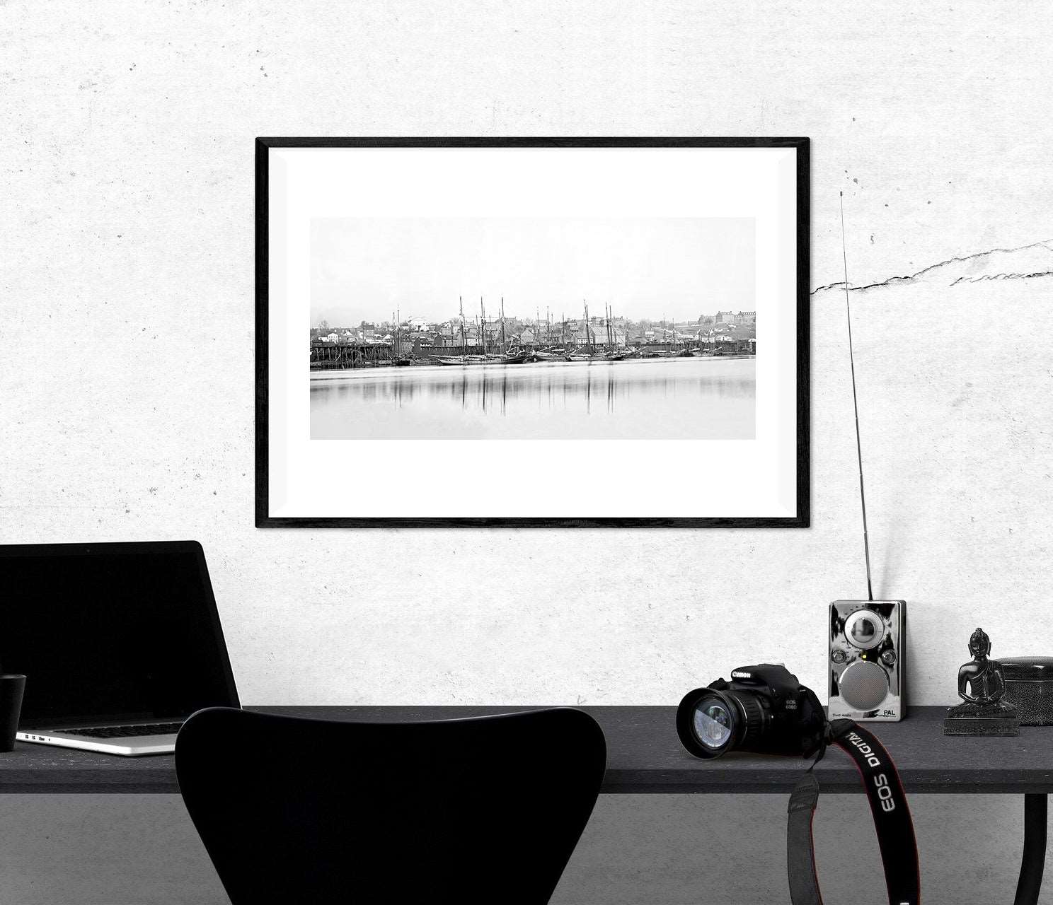 A framed paper print of a vintage photograph of the Georgetown Waterfront hanging above a desk