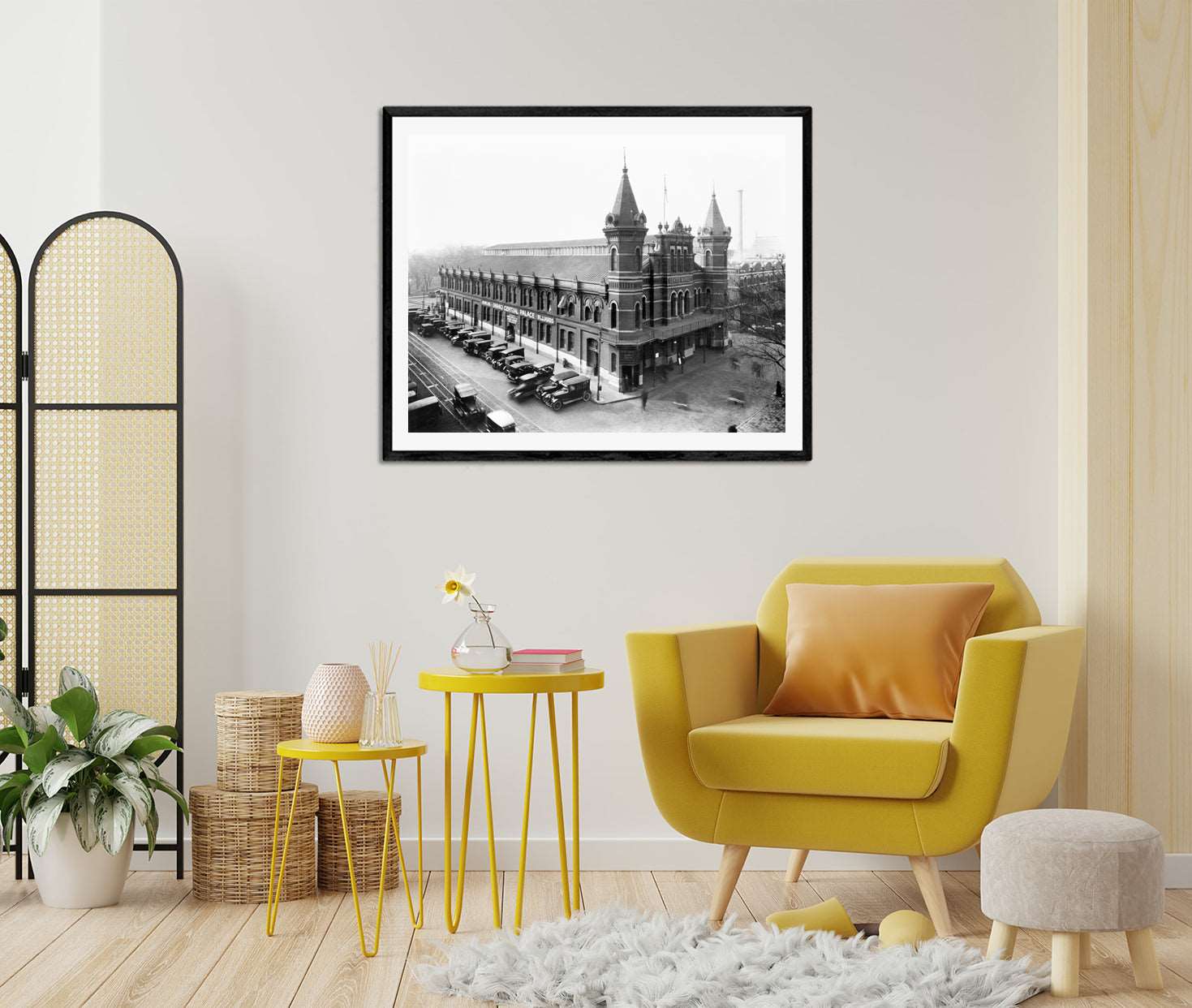 A framed print of a photograph of Grand Central Palace in DC hanging in a living room with yellow furniture