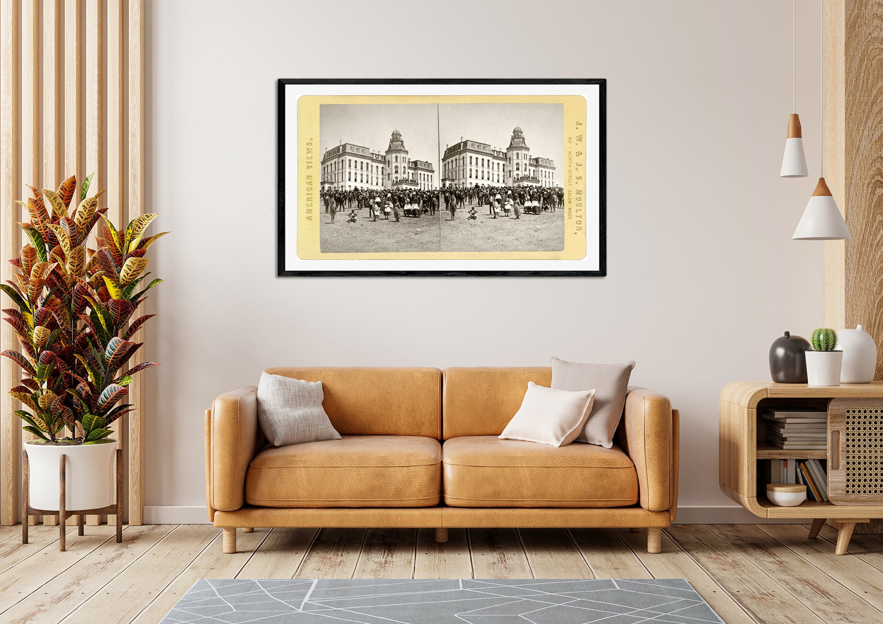 A framed paper print of a vintage stereograph card hangs above a couch in a living room