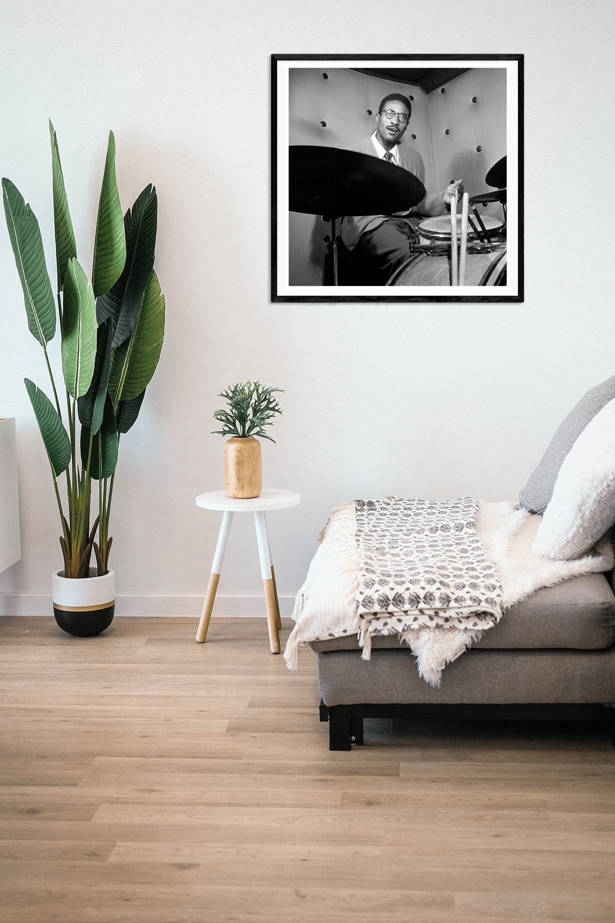 A living room with a framed paper print on the wall of a vintage photograph of Max Roach