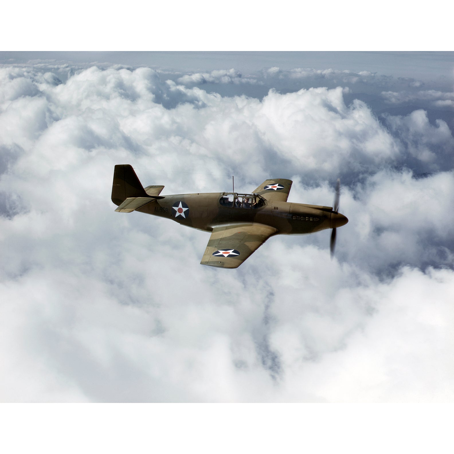 Vintage photograph of a P-51 Mustang Fighter above the clouds