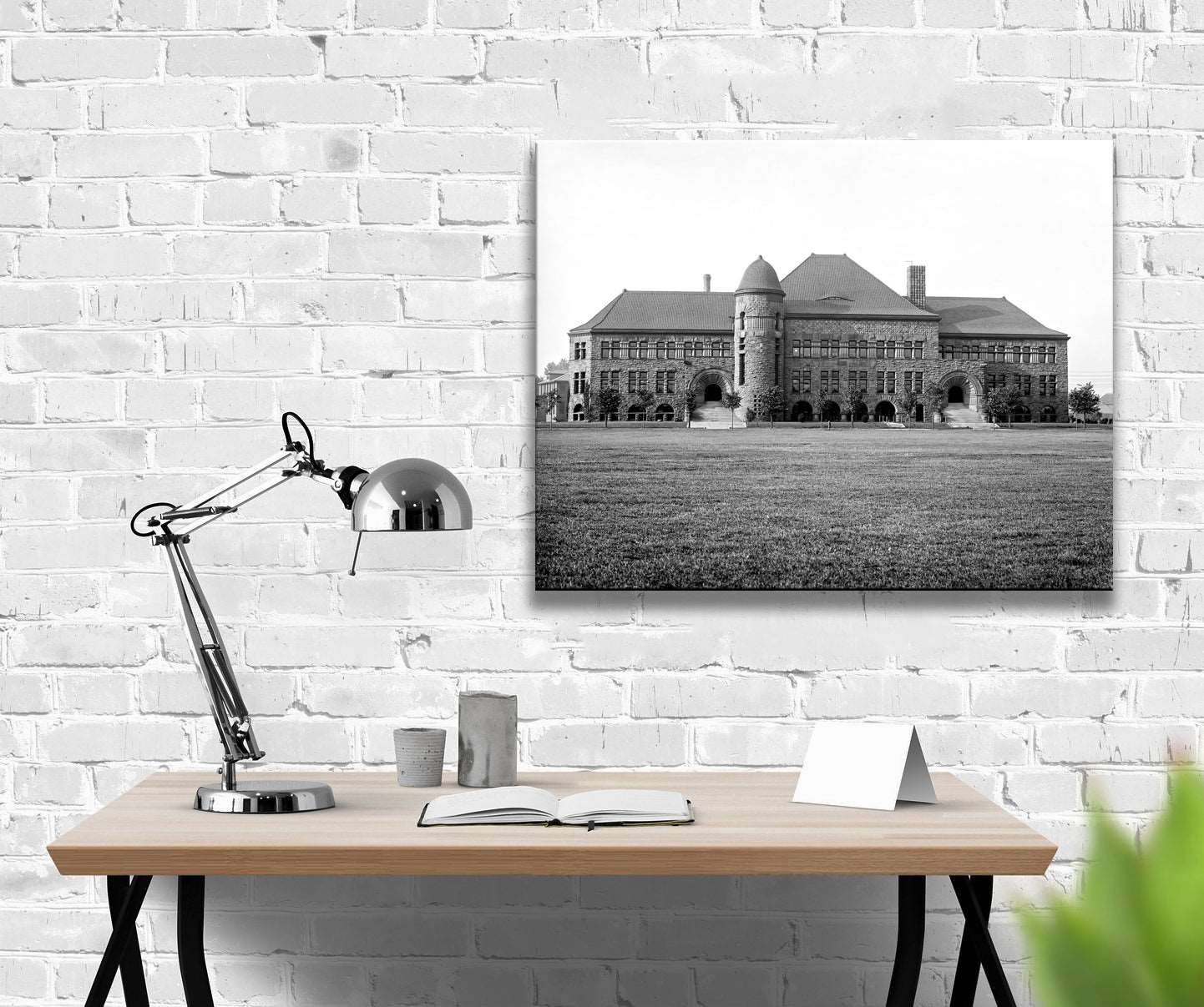 A digitally rendered office space with a canvas print of a photograph of Pillsbury Hall hanging on a brick wall