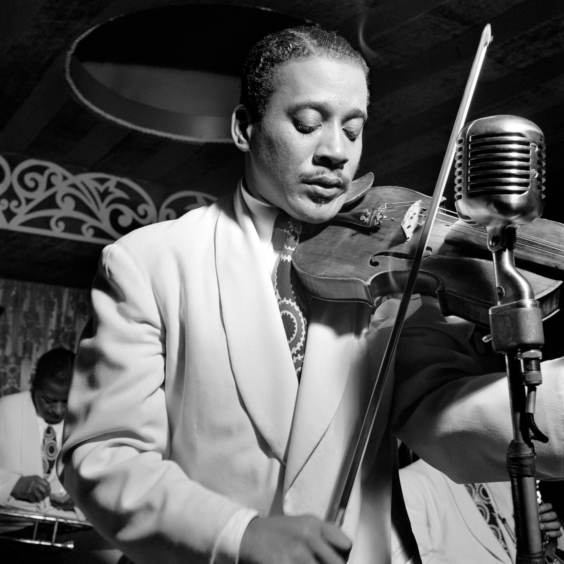 A vintage, black and white photograph of Ray Nance performing live