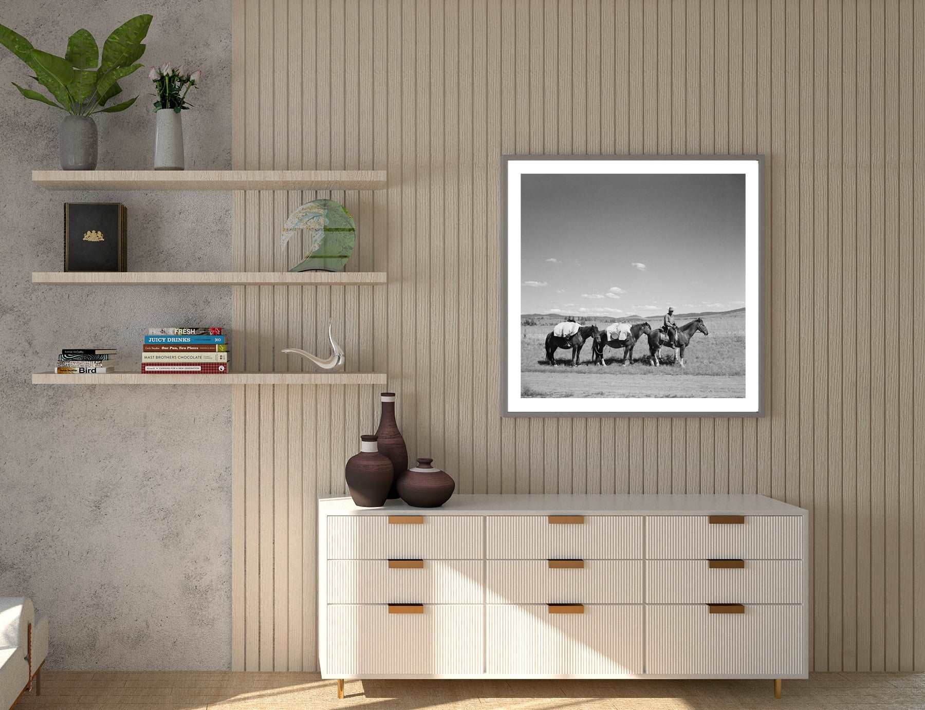 A room with a slatted wall, featuring a framed paper print of a photograph of a sheep herder with horses