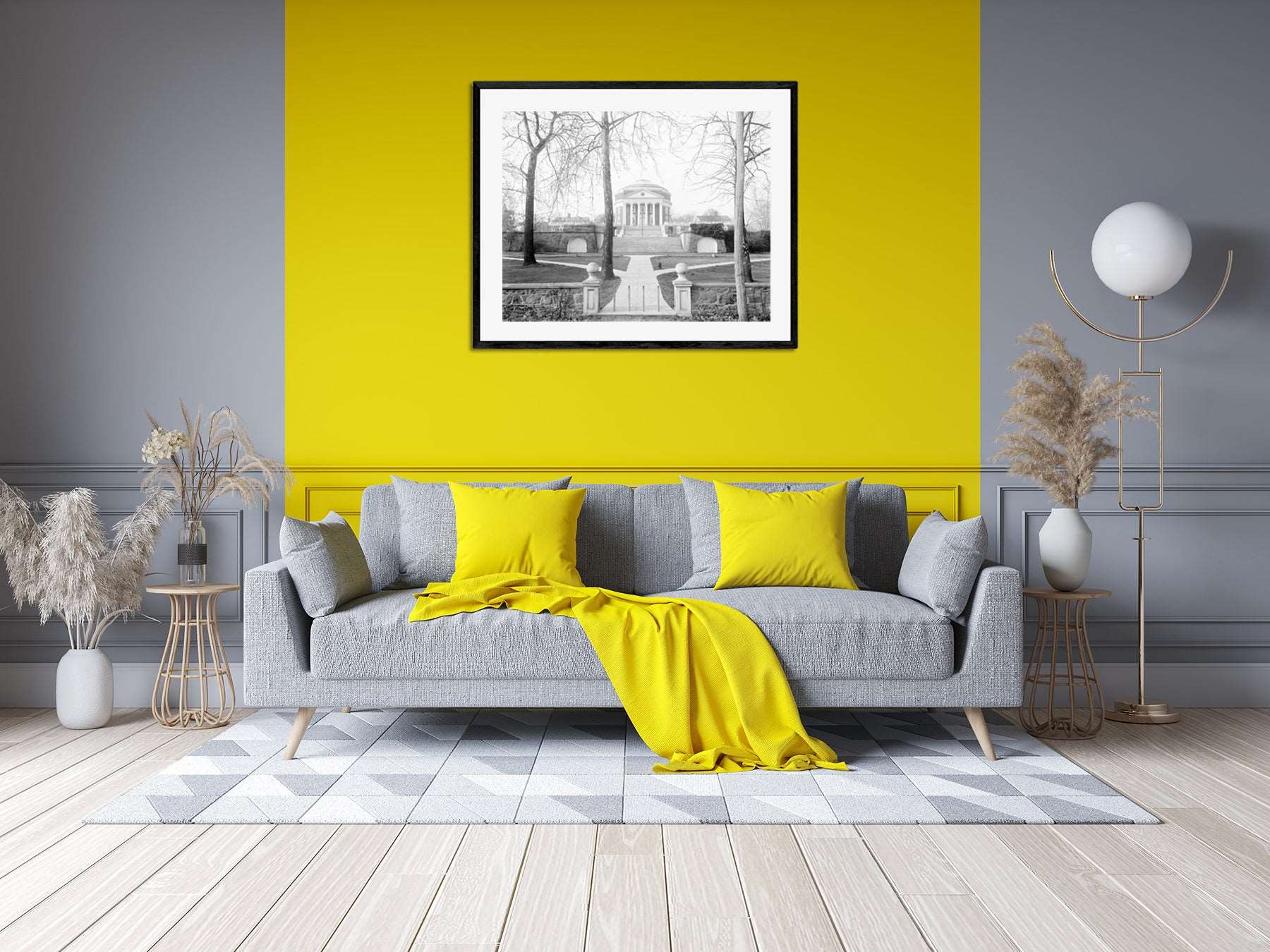 A photograph of a living room with yellow accents, with a framed paper print of vintage photography on the wall