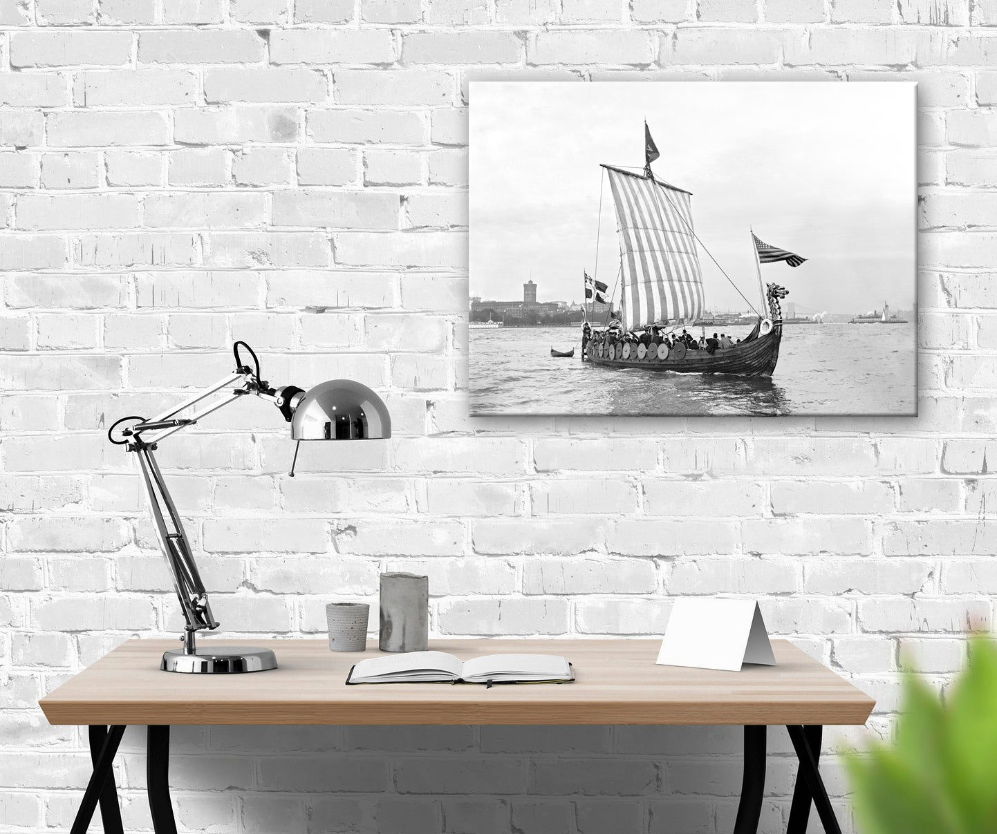 A canvas pirnt of a vintage photograph of a Viking replica ship hanging on a brick wall