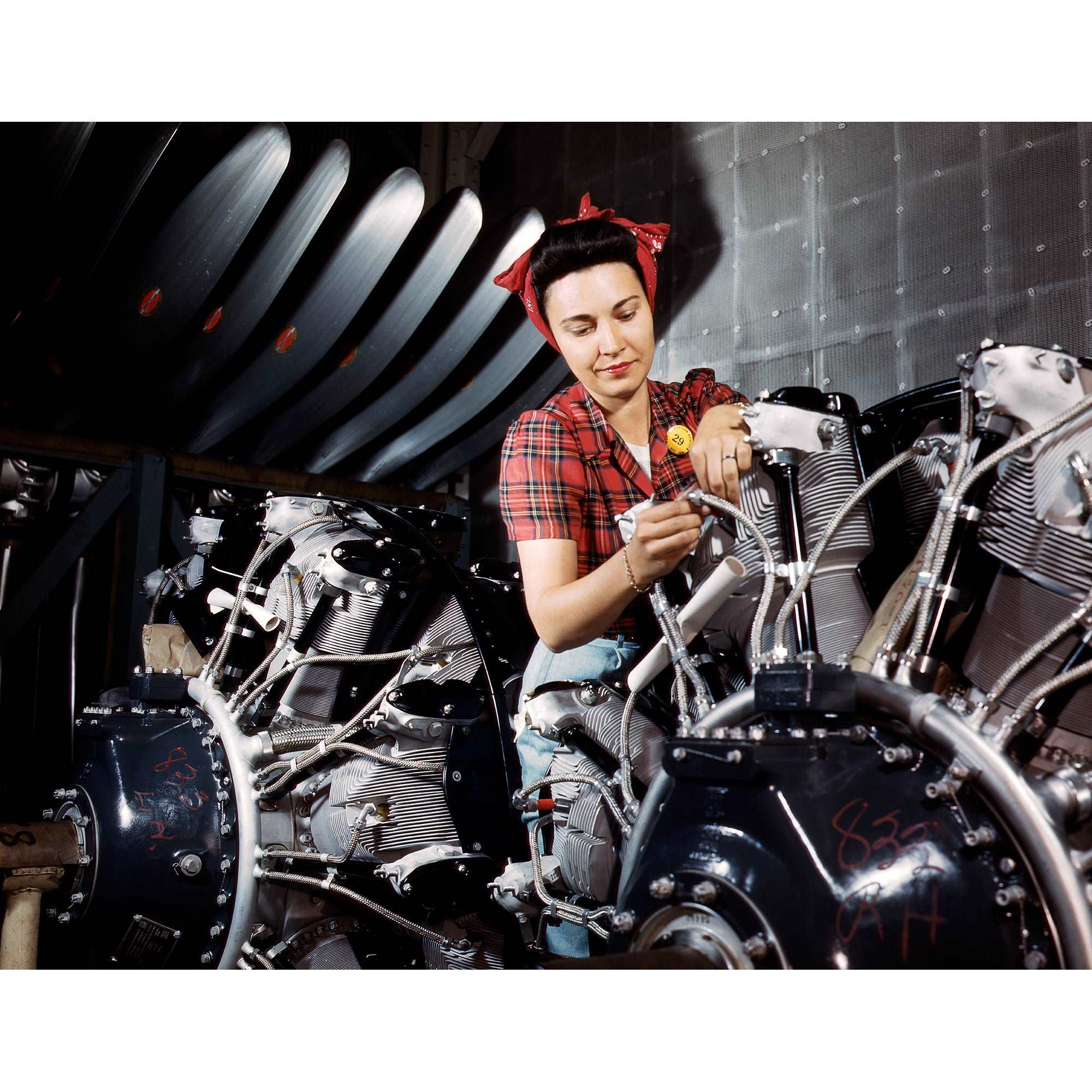 A full color vintage photograph of a Woman Working on Airplane Motor