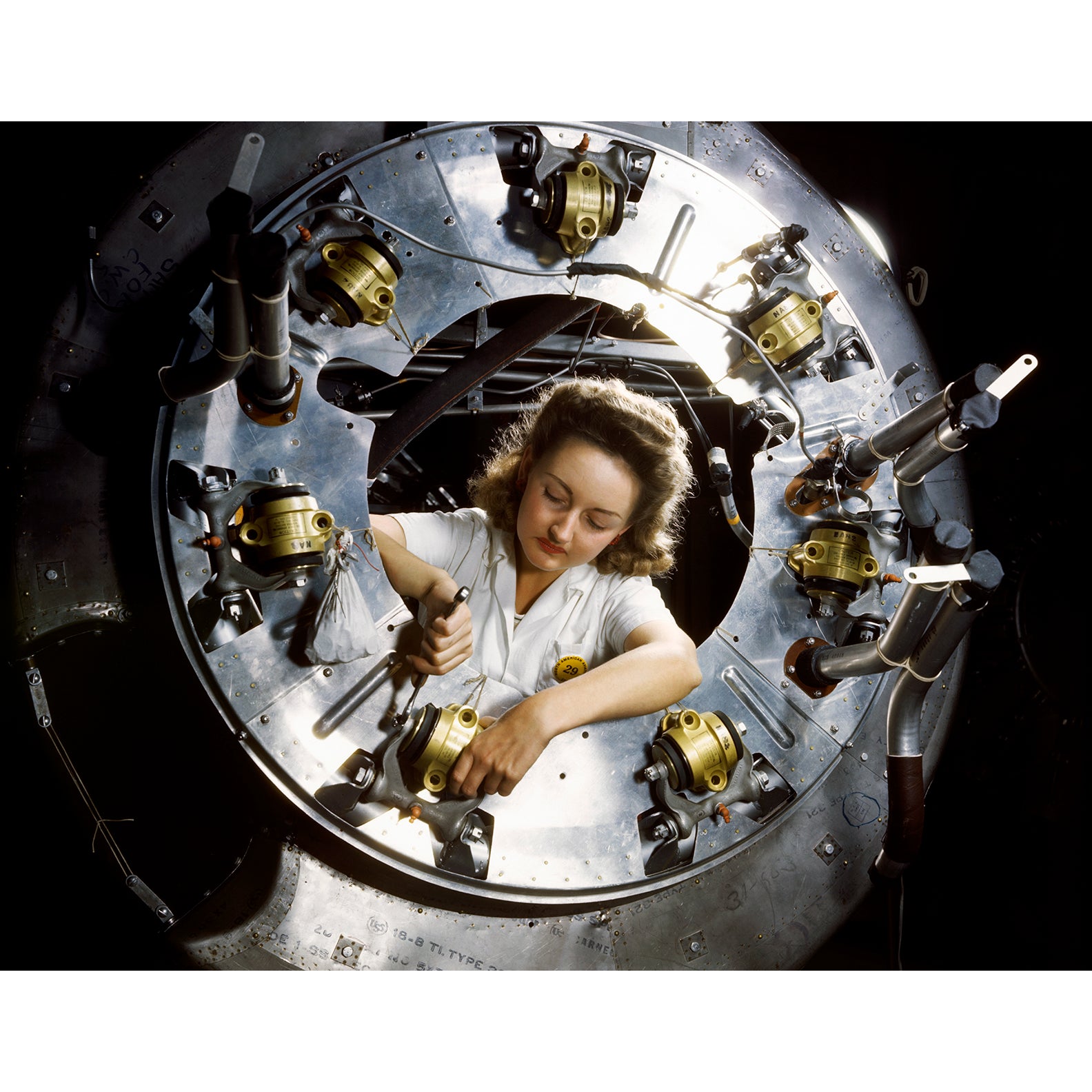 A vintage 1940s photograph of a woman working on a section of a B-25 Bomber