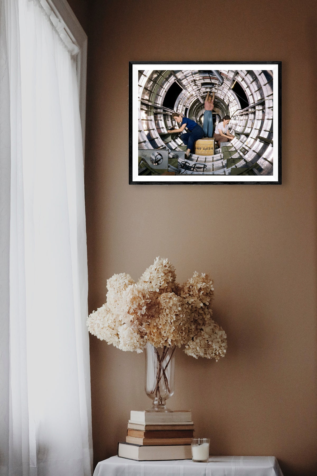 A digital mockup of a framed reproduction print of a photograph from the 1940s featuring three women working on a B-17 Bomber