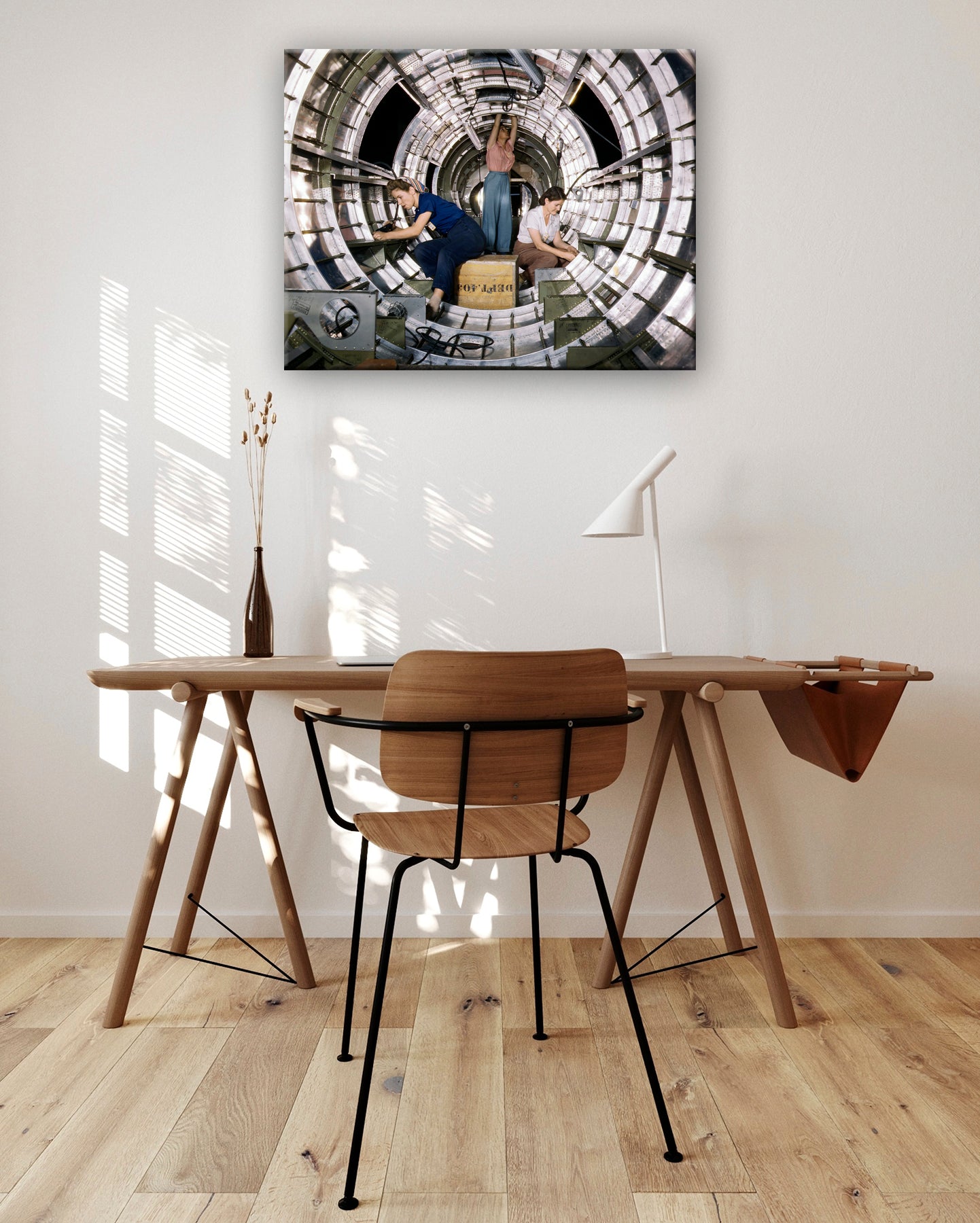 A digital rendering of a vintage photograph of women working on a B-17 Bomber printed on canvas and displayed above a desk