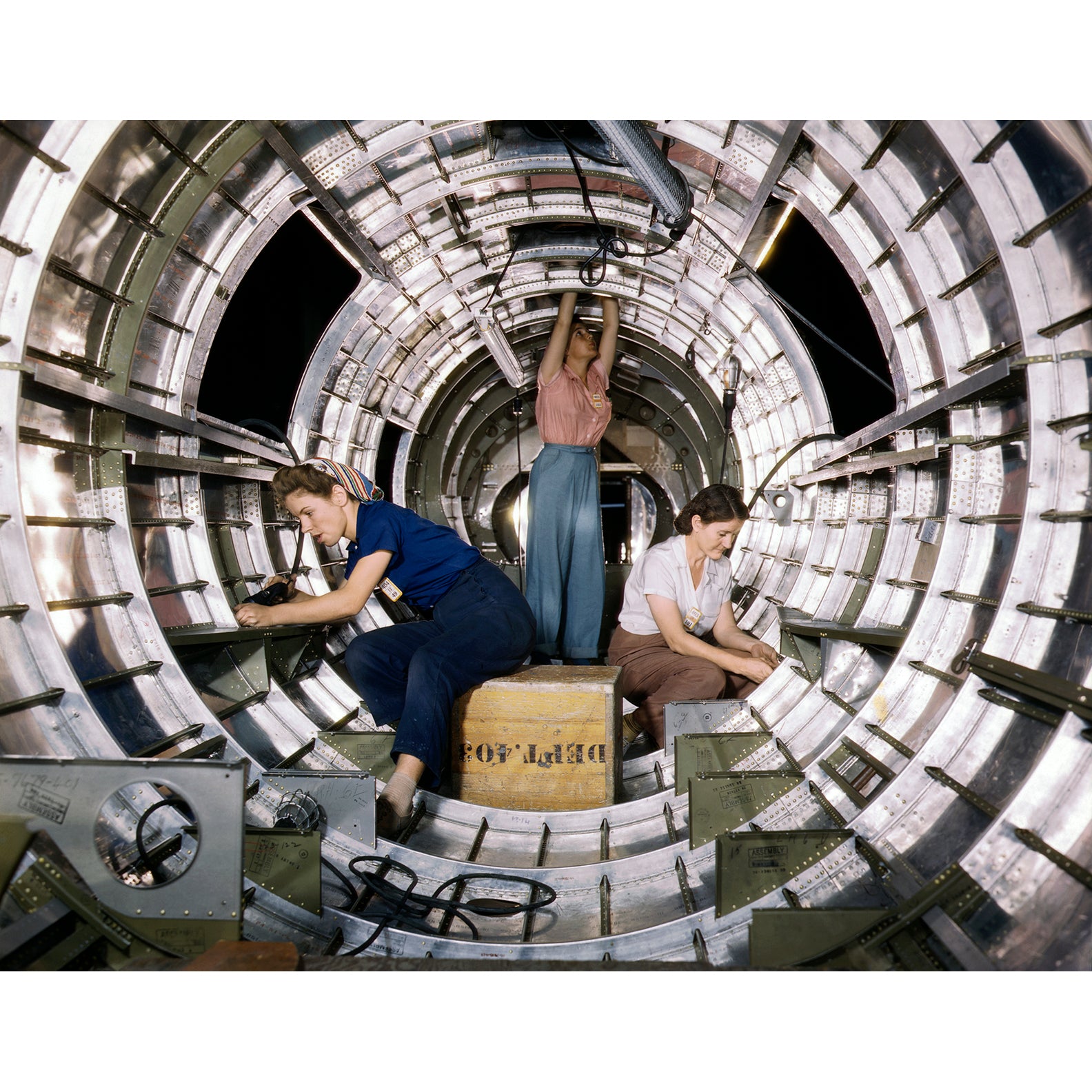 A 1940s vintage photograph showing three women working on a B-17 Bomber