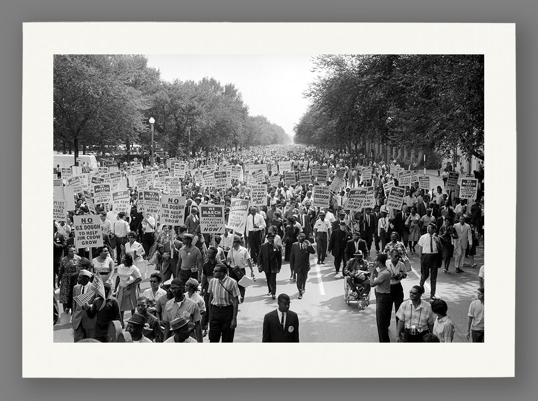 Black and white photograph of the March on Washington with people holding signs, printed on paper.