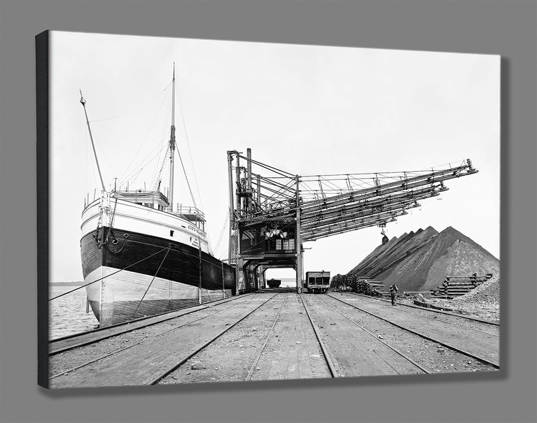 A canvas print mockup featuring a black and white, vintage image of a ship at Hannas Ore Plant