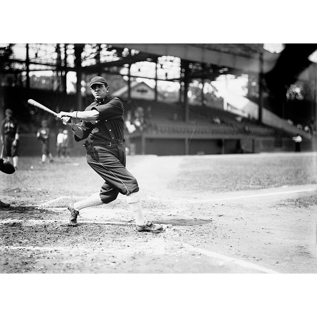 Vintage black and white photograph of Harry Lord swinging a bat on a field.