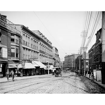 A historic photograph of Middle Street in Portland, Maine, showing stores lining the street and people going about their days