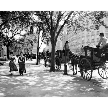 A vintage, black and white photograph of women passing a cab stand of horse-drawn carriages