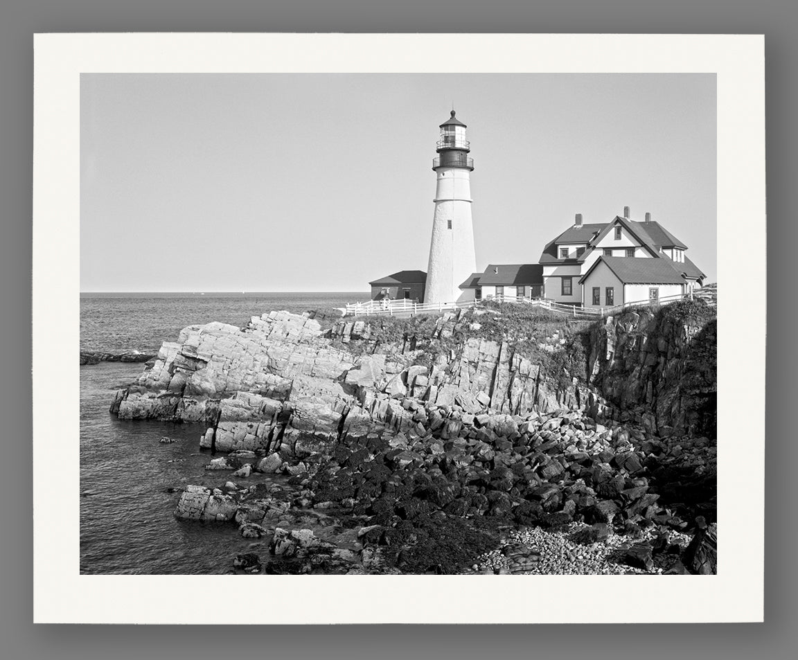 A digital mockup of an archival paper print featuring a historic photograph of the Portland Head Light in Maine