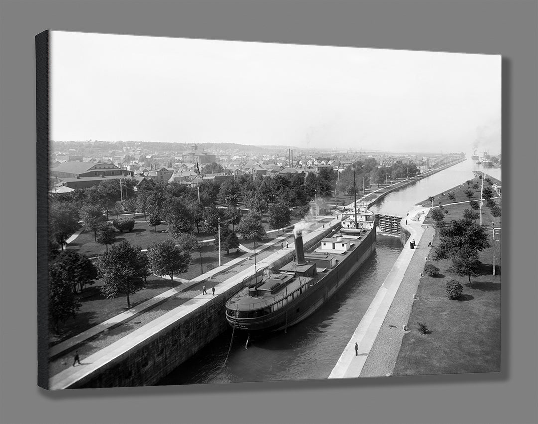 A rendering of a stretched canvas print of a vintage photograph depicting a ship going through the Sault Ste Marie locks