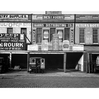 A vintage photograph of a row of waterfront warehouses with numerous advertisements, taken by Walker Evans in Louisiana