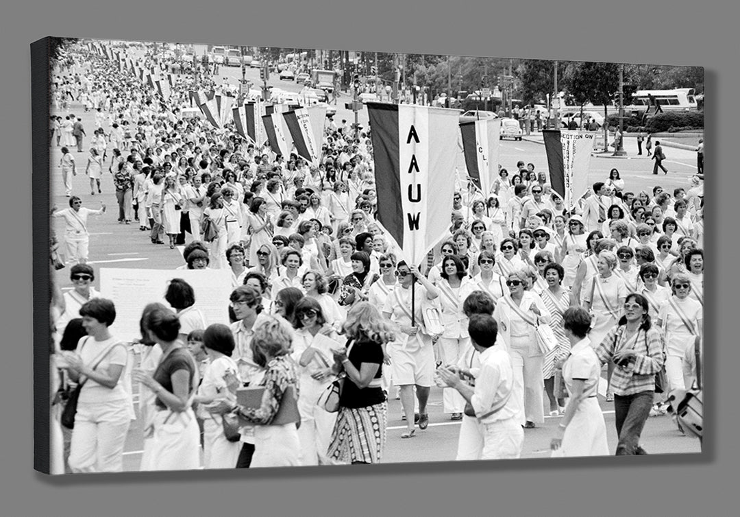 Black and white photo of a large group of people at a protest or demonstration, holding signs and banners, printed on canvas.