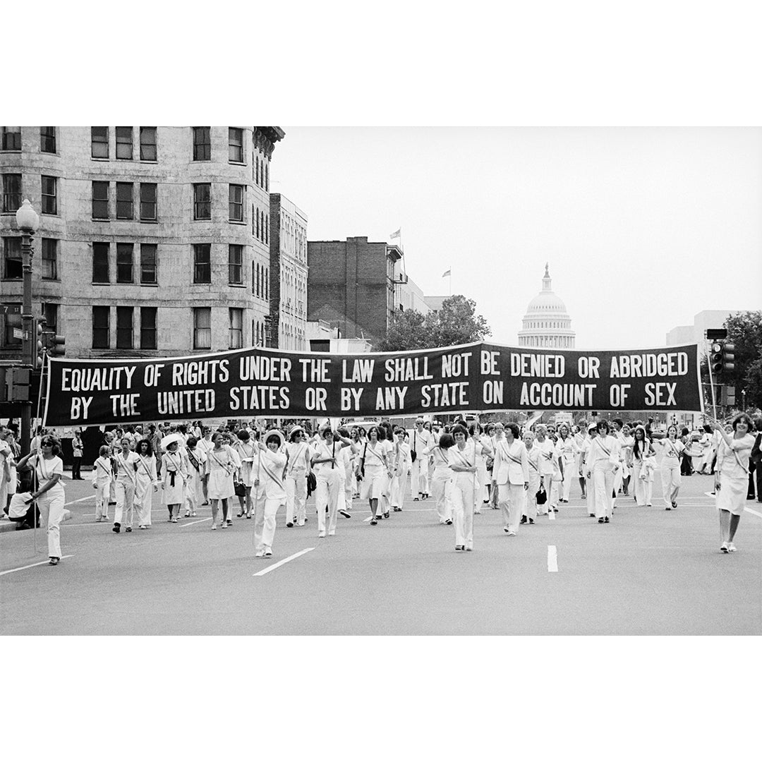 Protest march with a banner advocating for gender equality in Washington DC.
