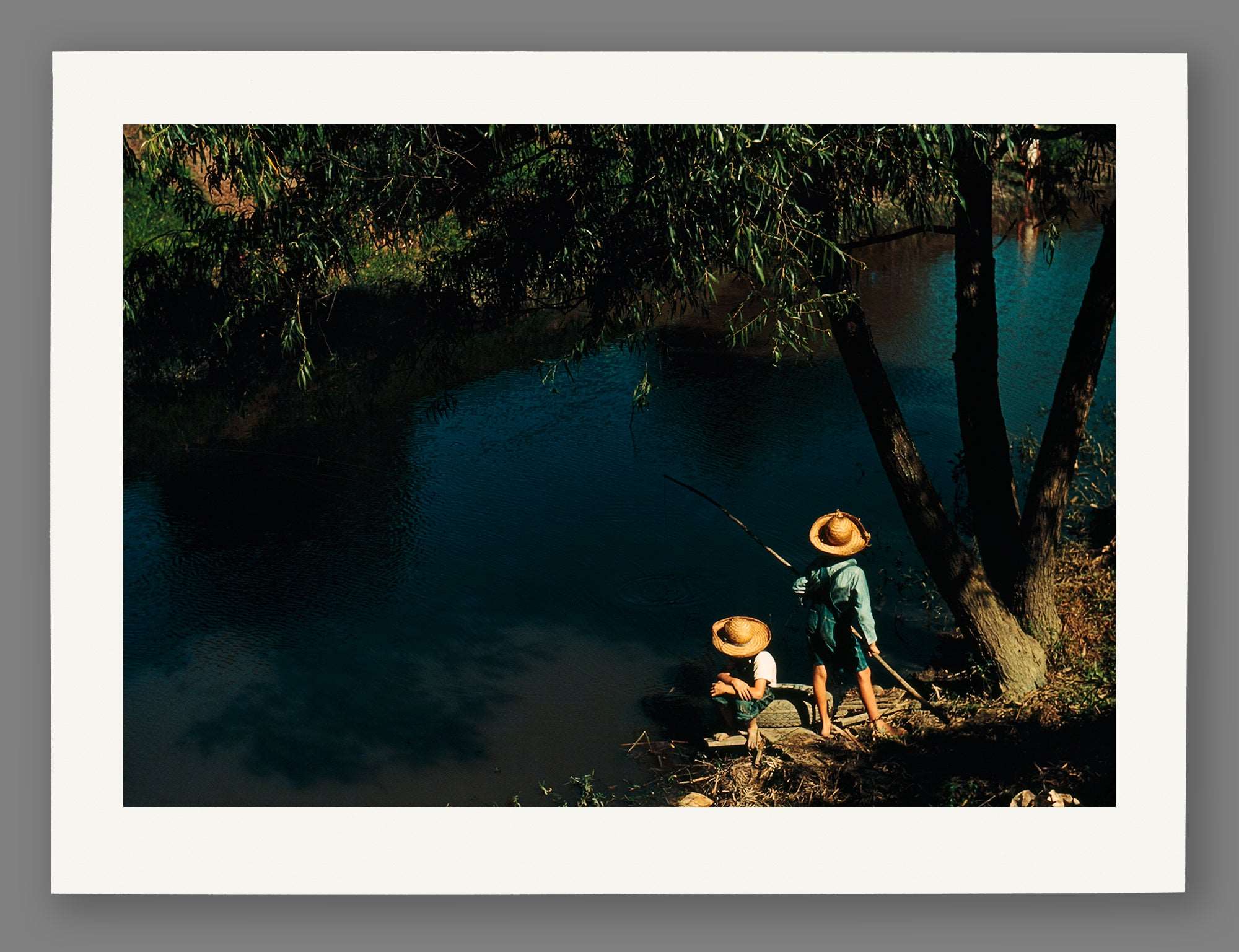 A fine art paper print of a vintage photograph of two boys fishing in a Bayou