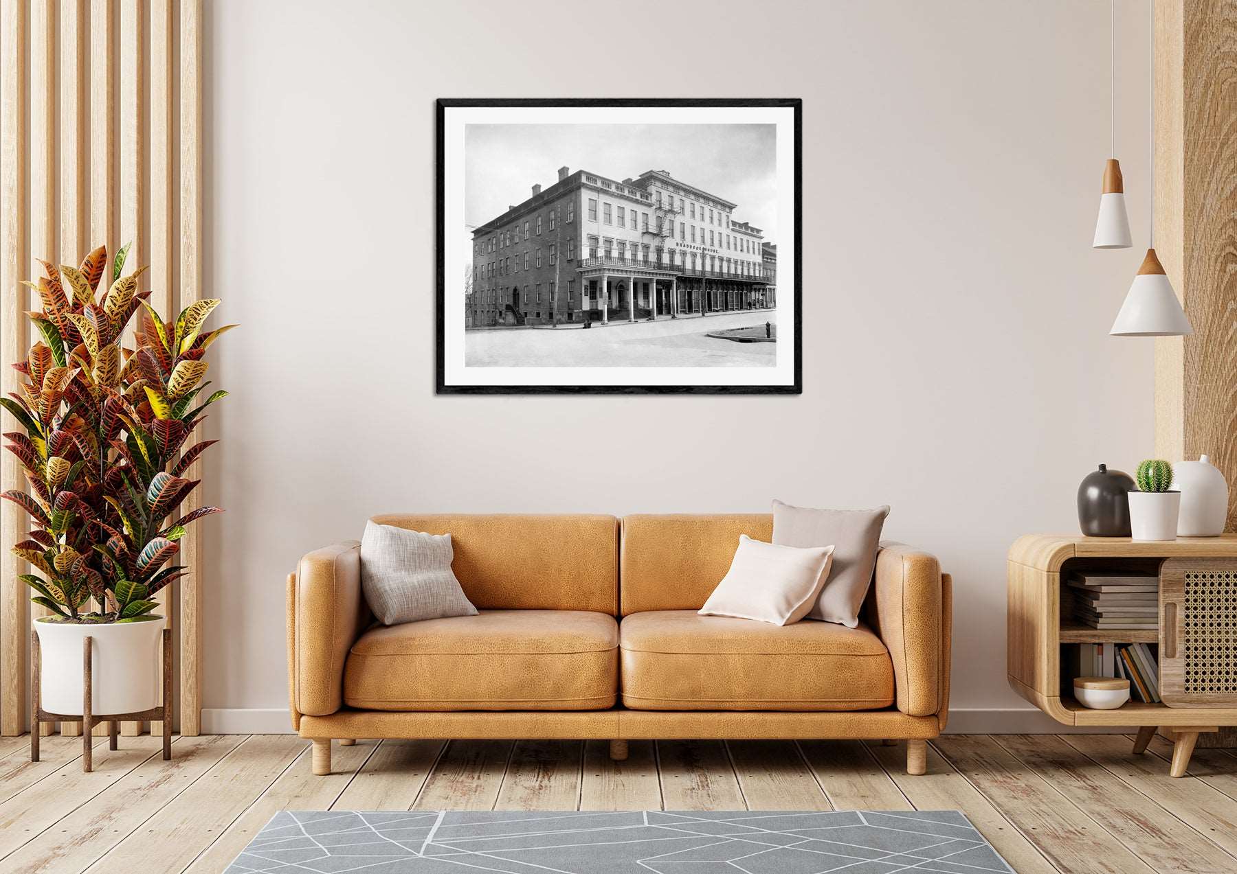 A framed paper print of Alexandria hanging on a living room wall above a yellow couch