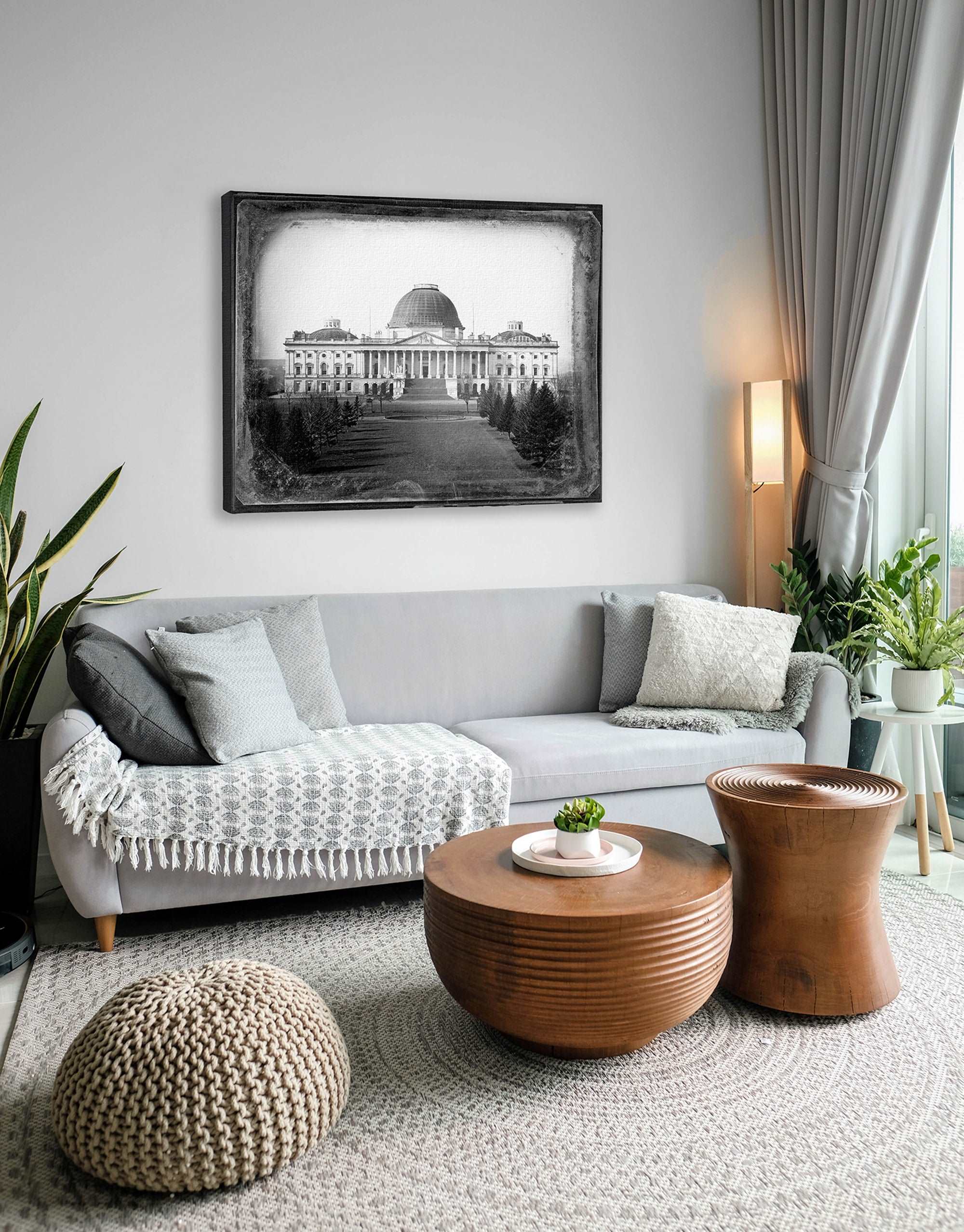 A living room with a gray couch and a canvas print of the Capitol Building hanging on the wall