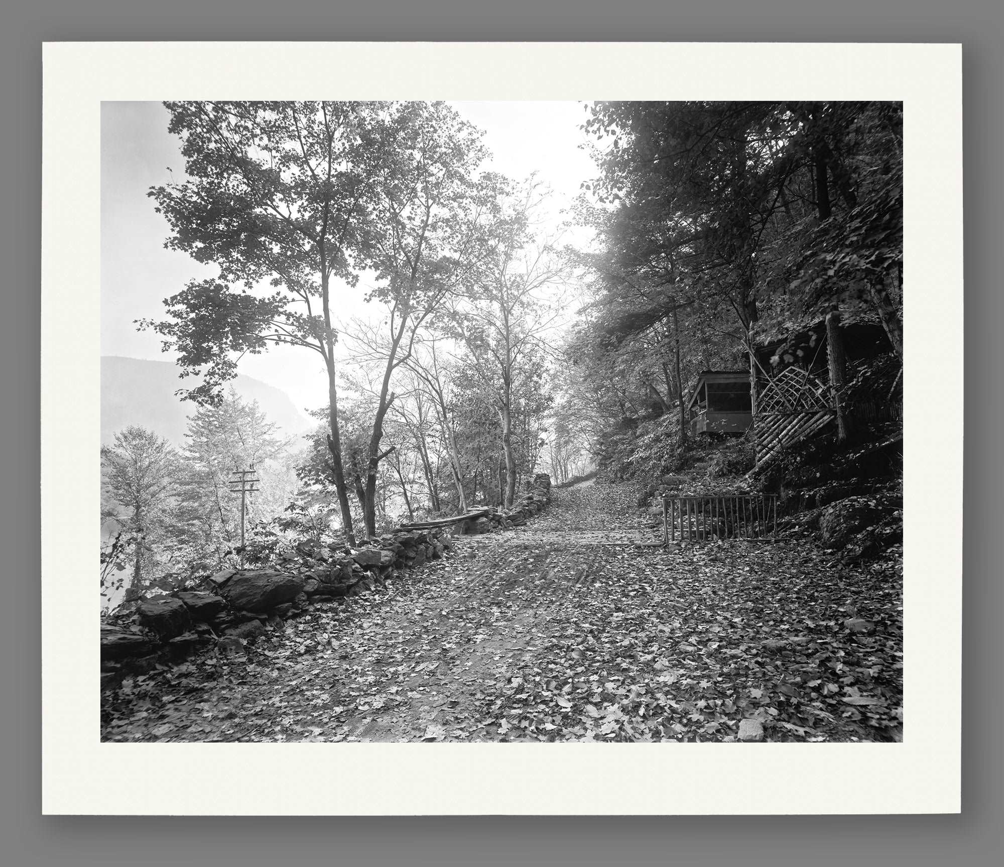 A mockup of a paper print of a black and white photograph of a trail along the Delaware Water Gap
