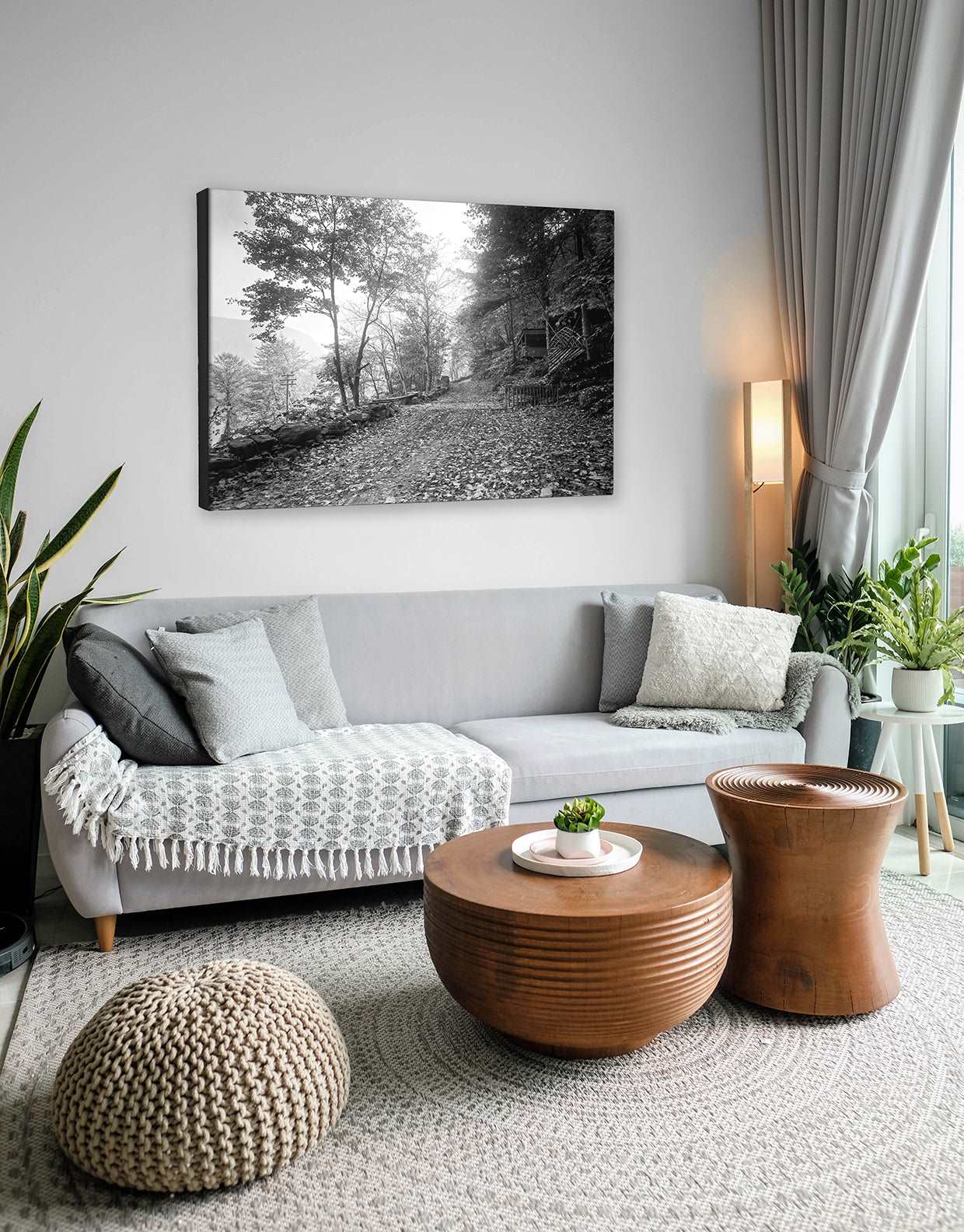 A neutral themed living room with a black and white canvas print of vintage photography on the wall