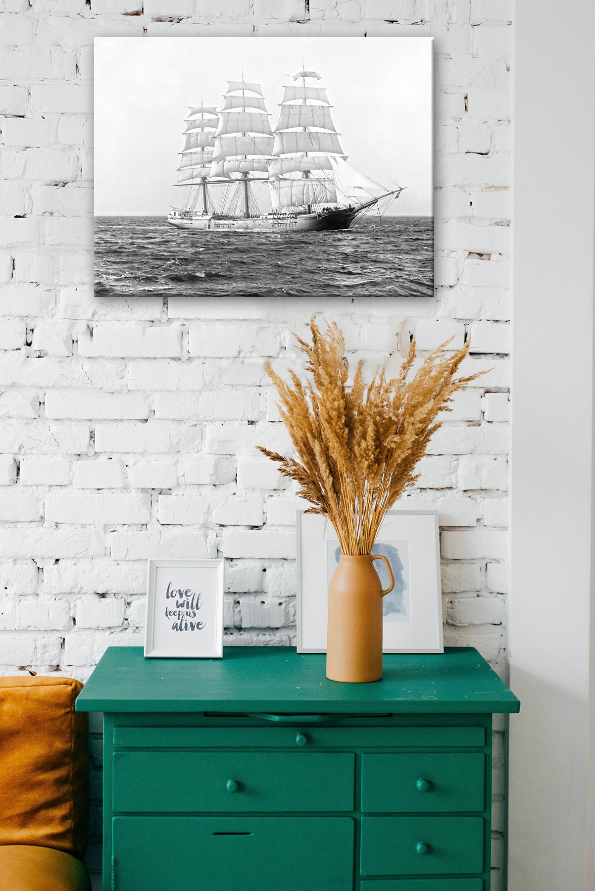 A room with a white brick wall and green storage table, featuring a canvas print hanging on the wall