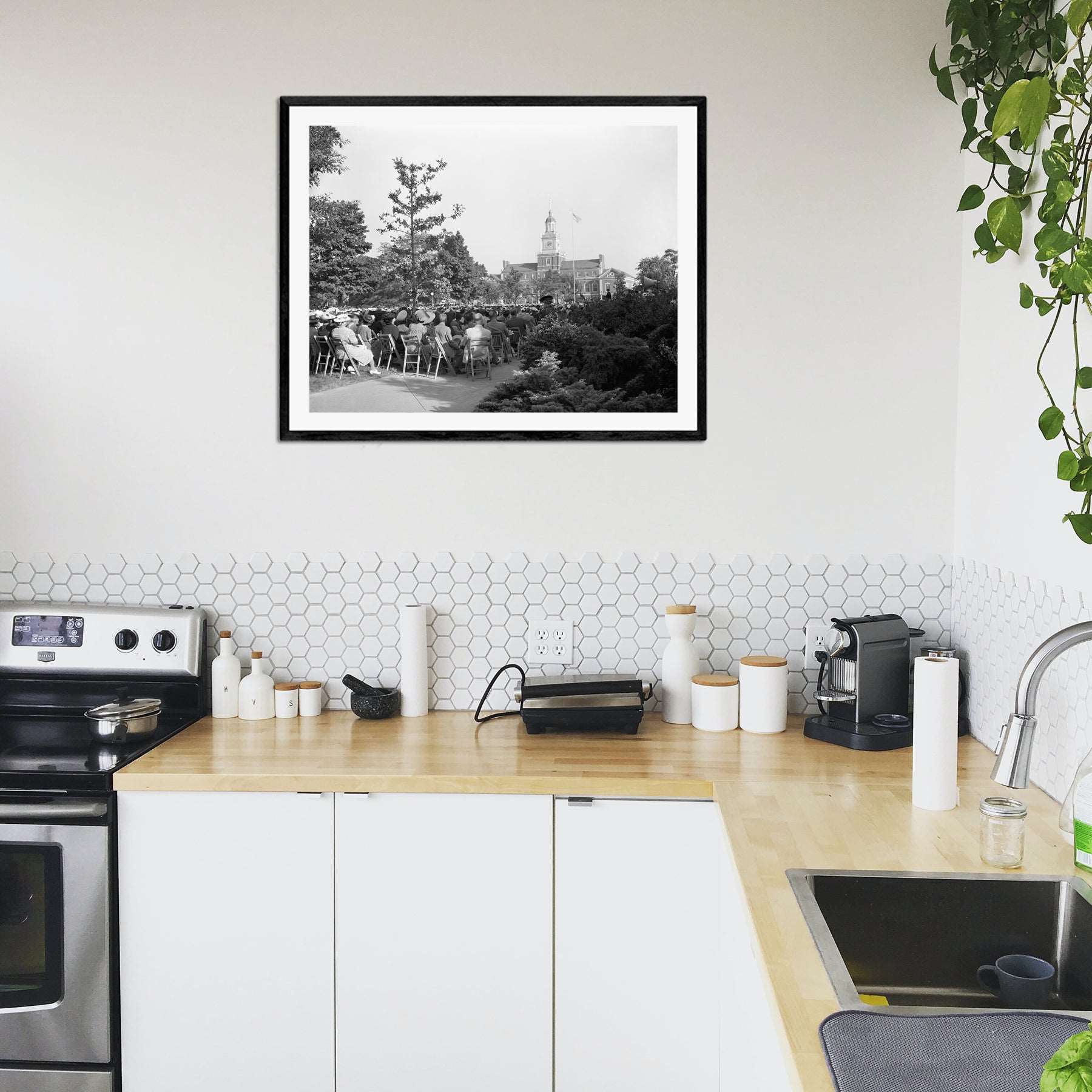 A modern kitchen decorated with a framed paper print of a vintage image of Howard University's commencement