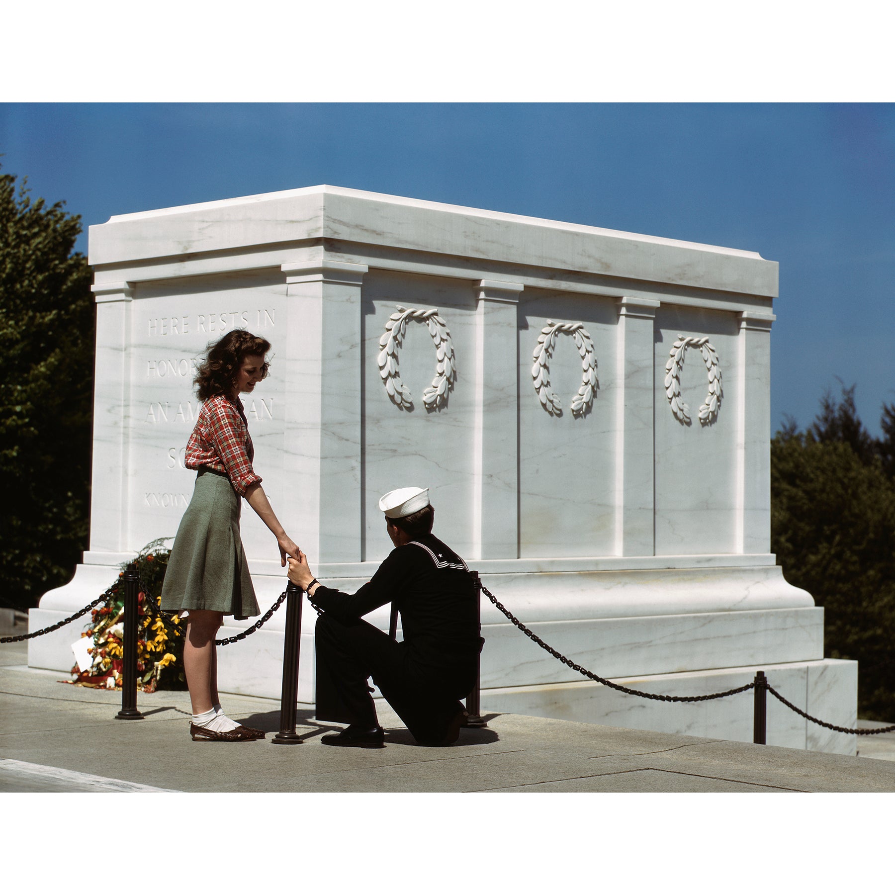 A vintage, color photograph of a couple in front of the Tomb of the Unknown Soldier