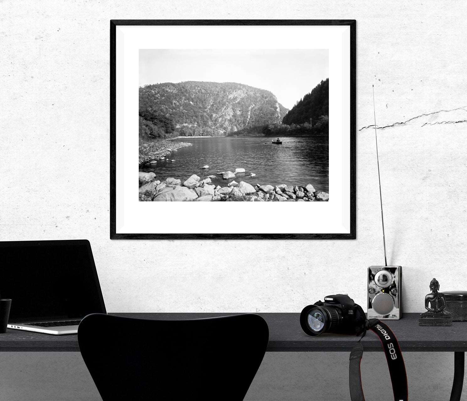A framed paper print hanging on a white wall, featuring a vintage photograph of a canoe on the Delaware Water Gap