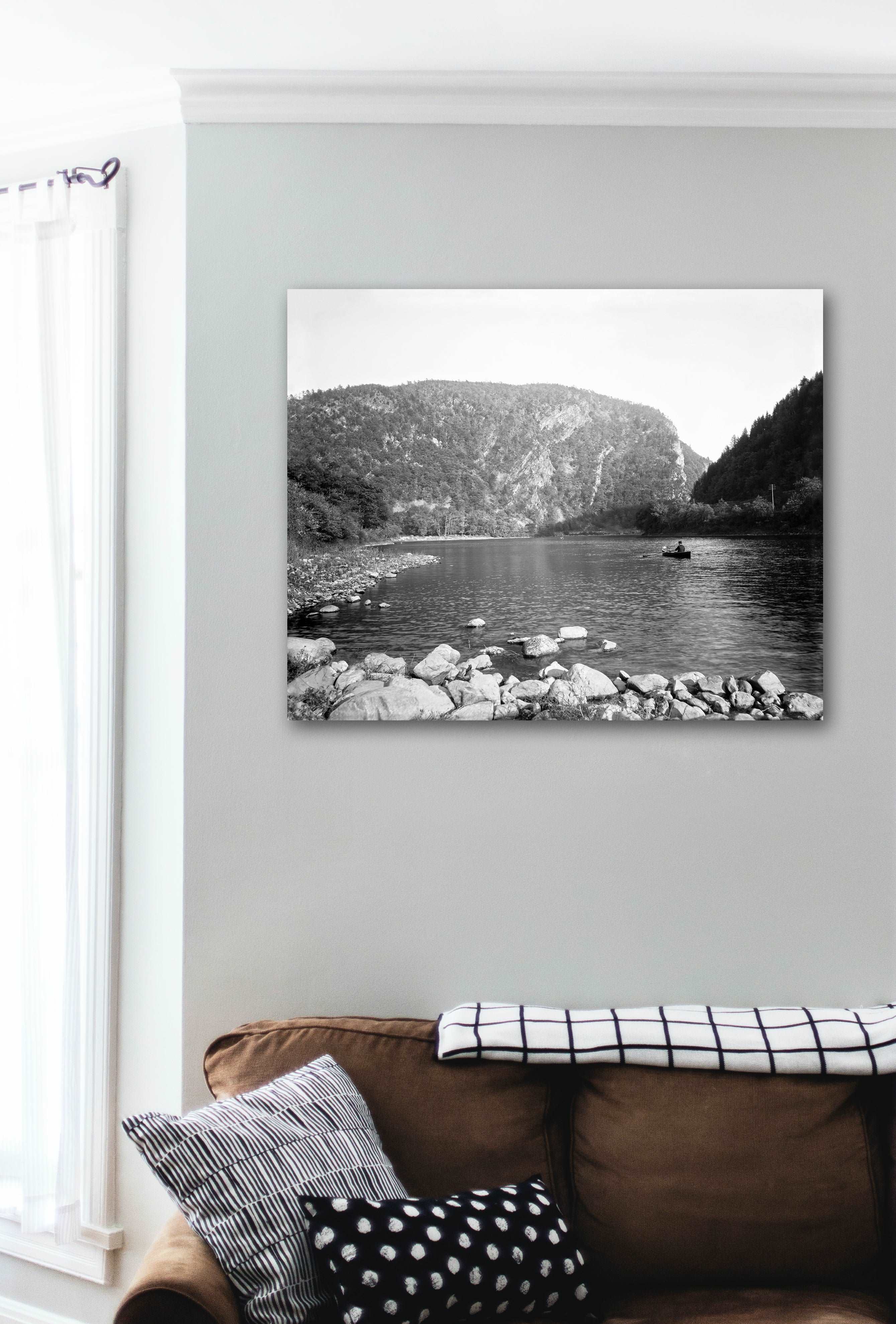 A canvas print hanging on the wall in a living room, featuring a vintage photograph of the Delaware Water Gap