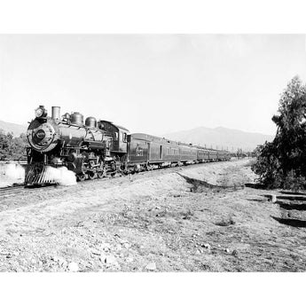 A vintage, black and white image of a Deluxe Overland Limited Train passing by